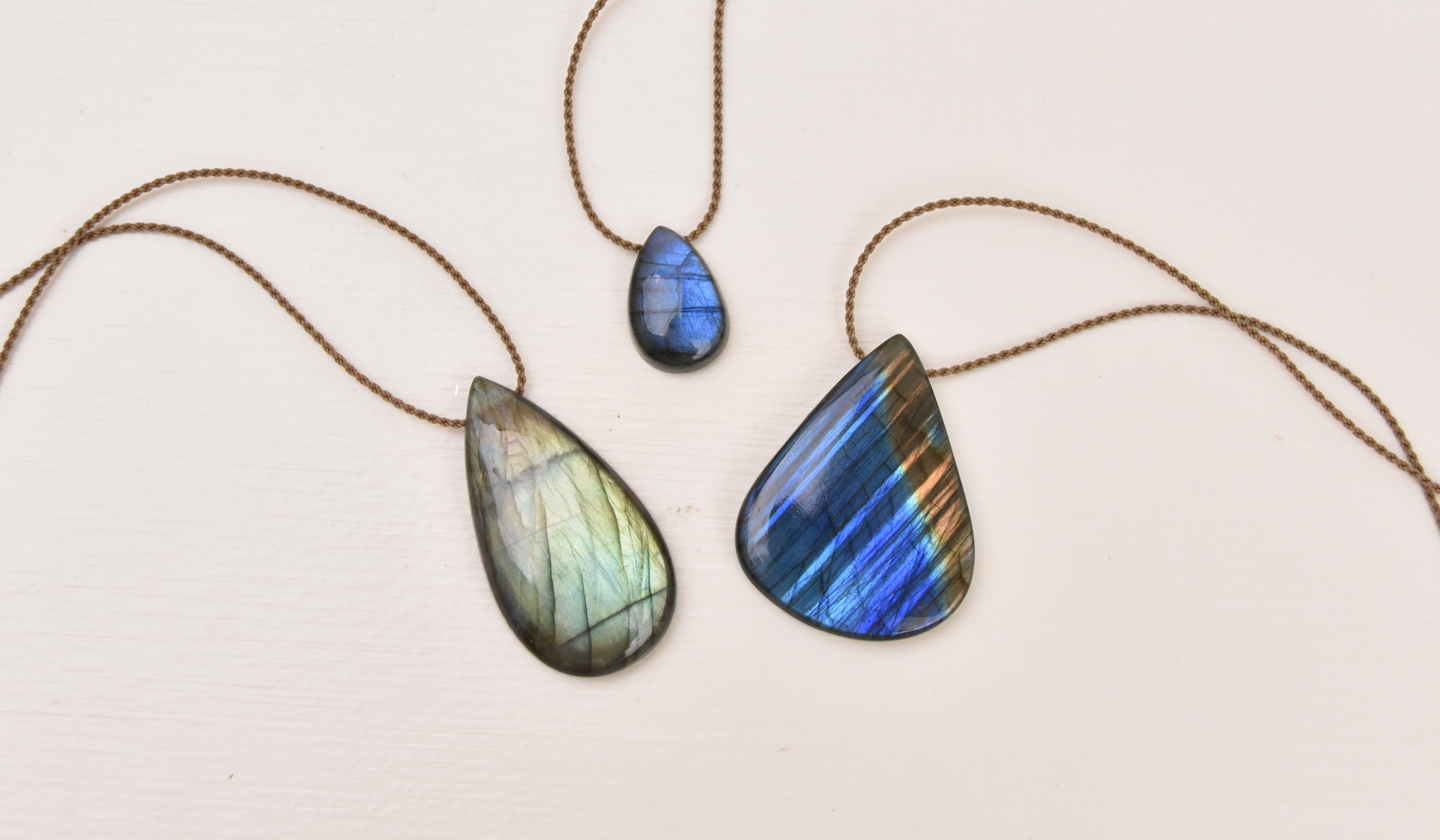 Raw labradorite stone showing the play of color against a dark base. Alt text: "Raw labradorite mineral showing blue and gold labradorescence