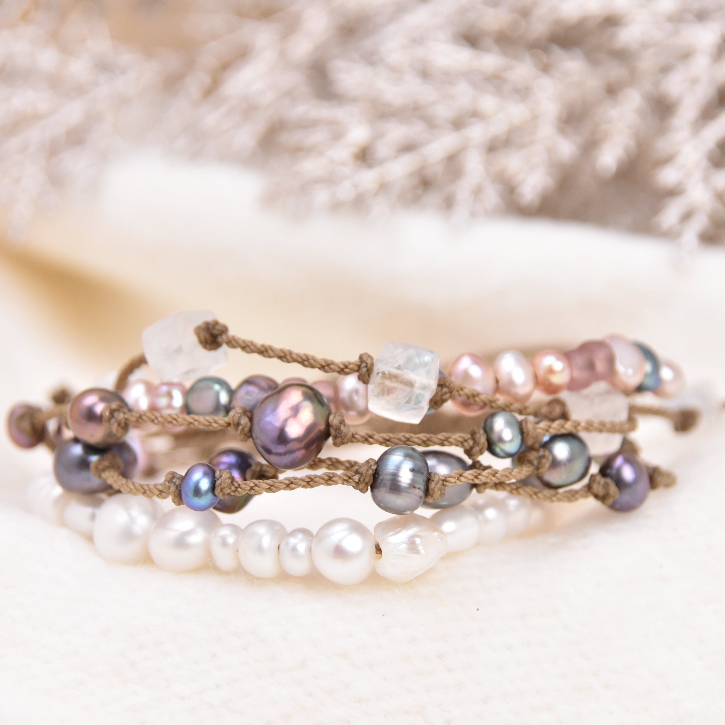 Multistrand beaded bracelet with pearls and crystals on a textured surface