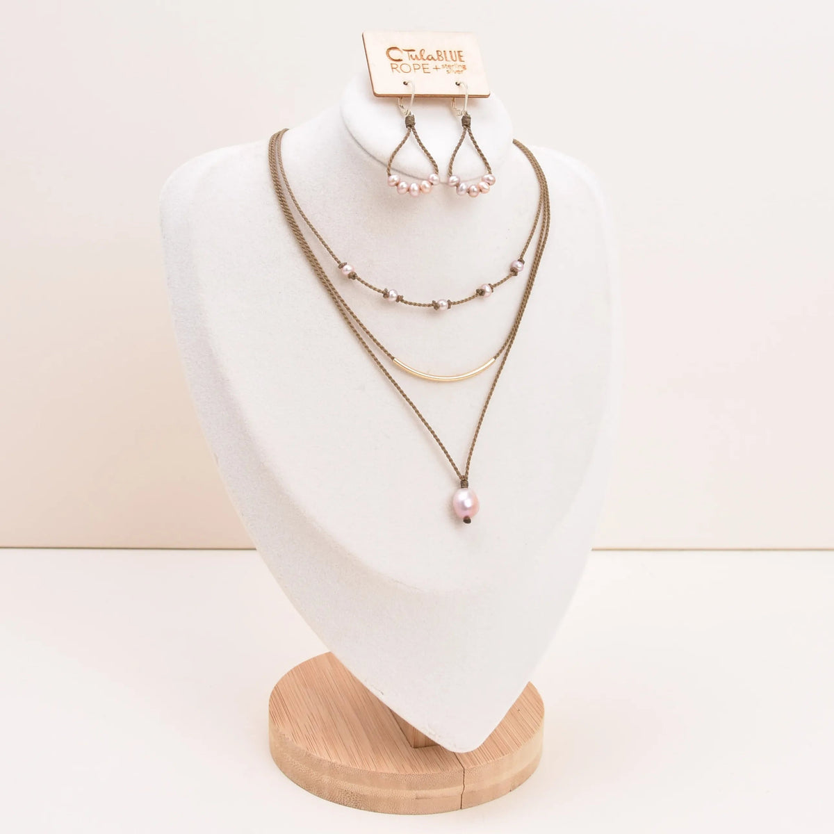Dripping in Pearls necklace stack with earrings in blush on bust with white background