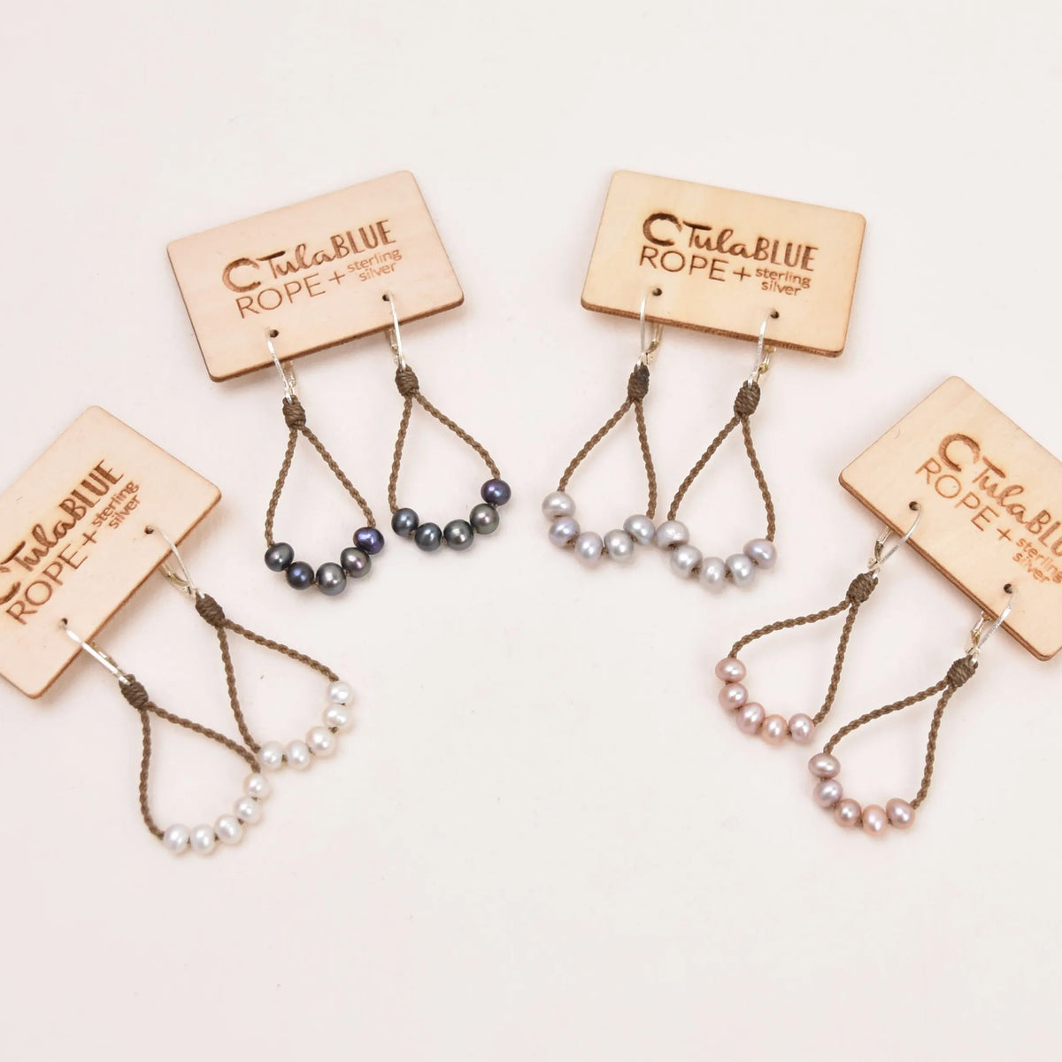 pearl dainty earrings in white, peacock, silver and blush with white background
