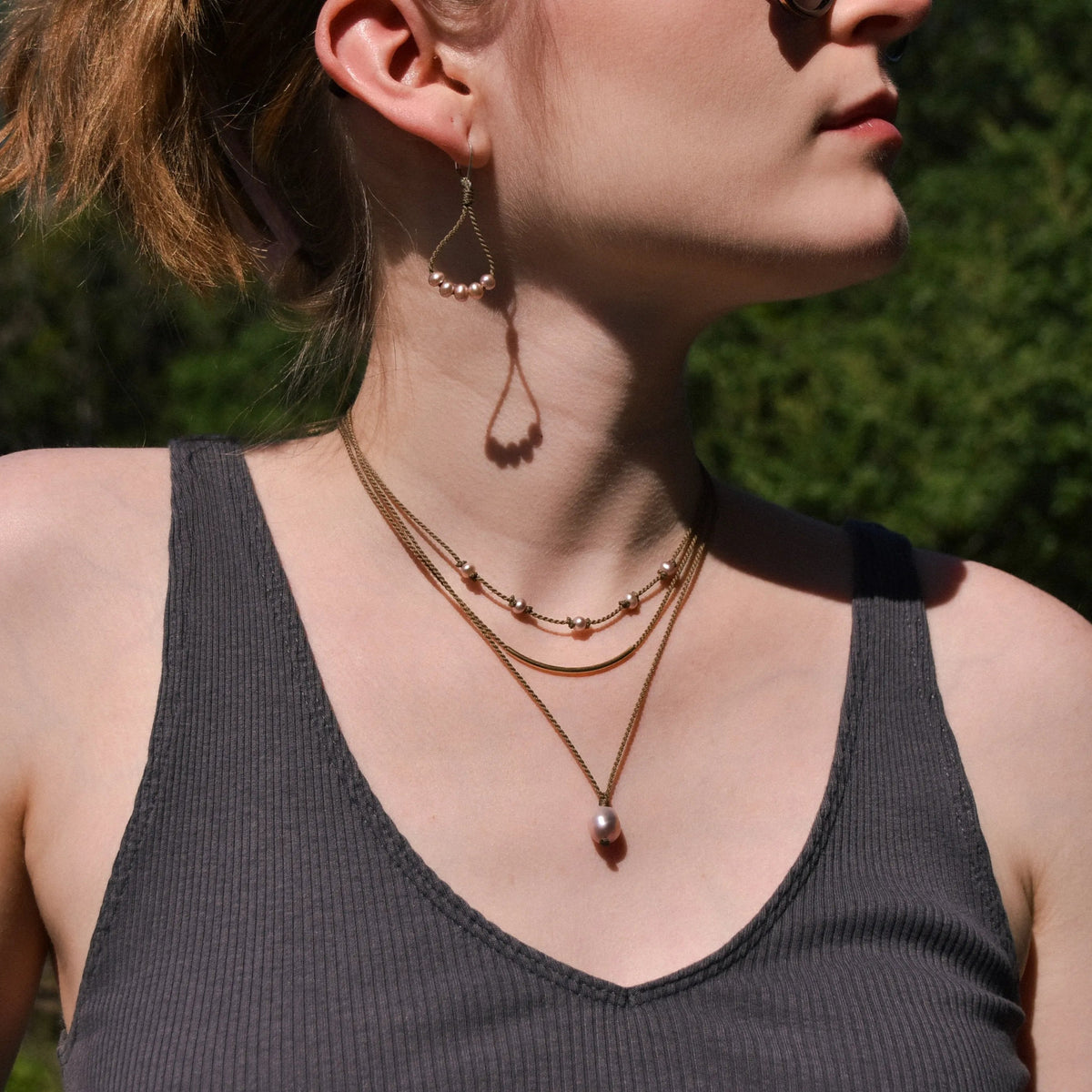Dripping in Pearls necklace stack with earrings in blush with earrings on model in front of trees