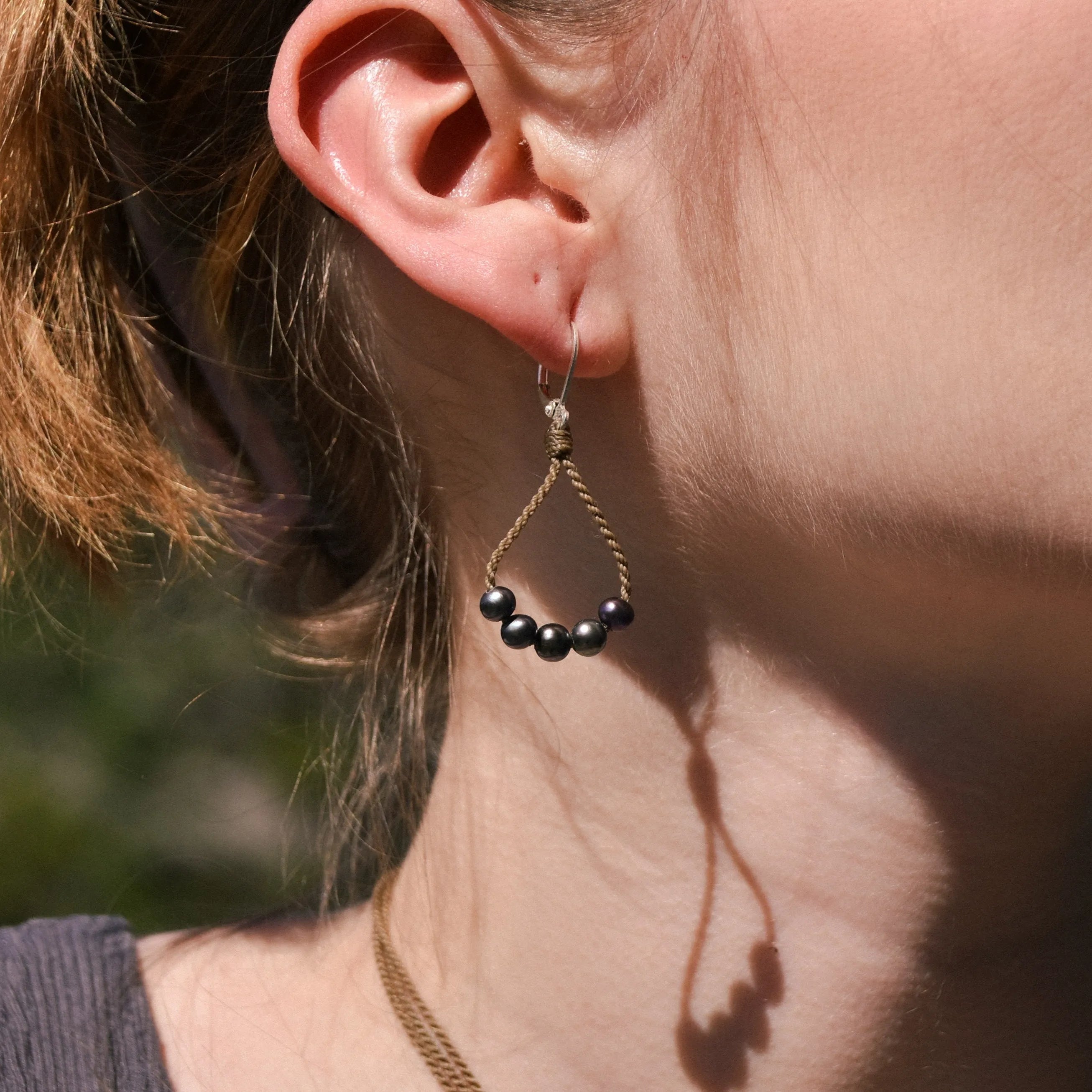 dainty pearl earrings closeup on model