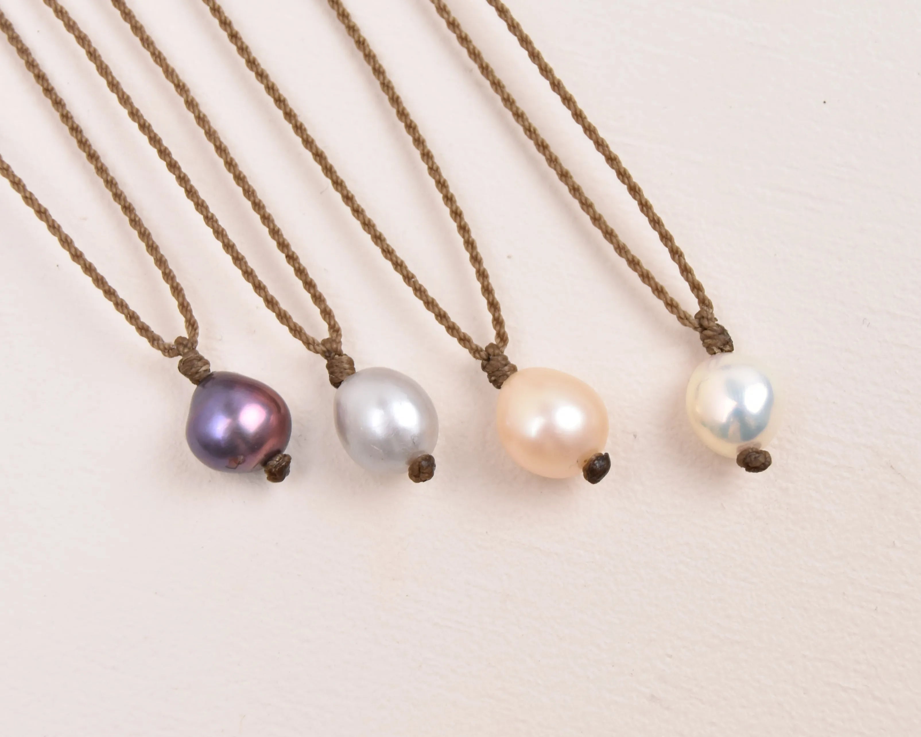 pearl drop necklace layout in peacock, silver, peach and white