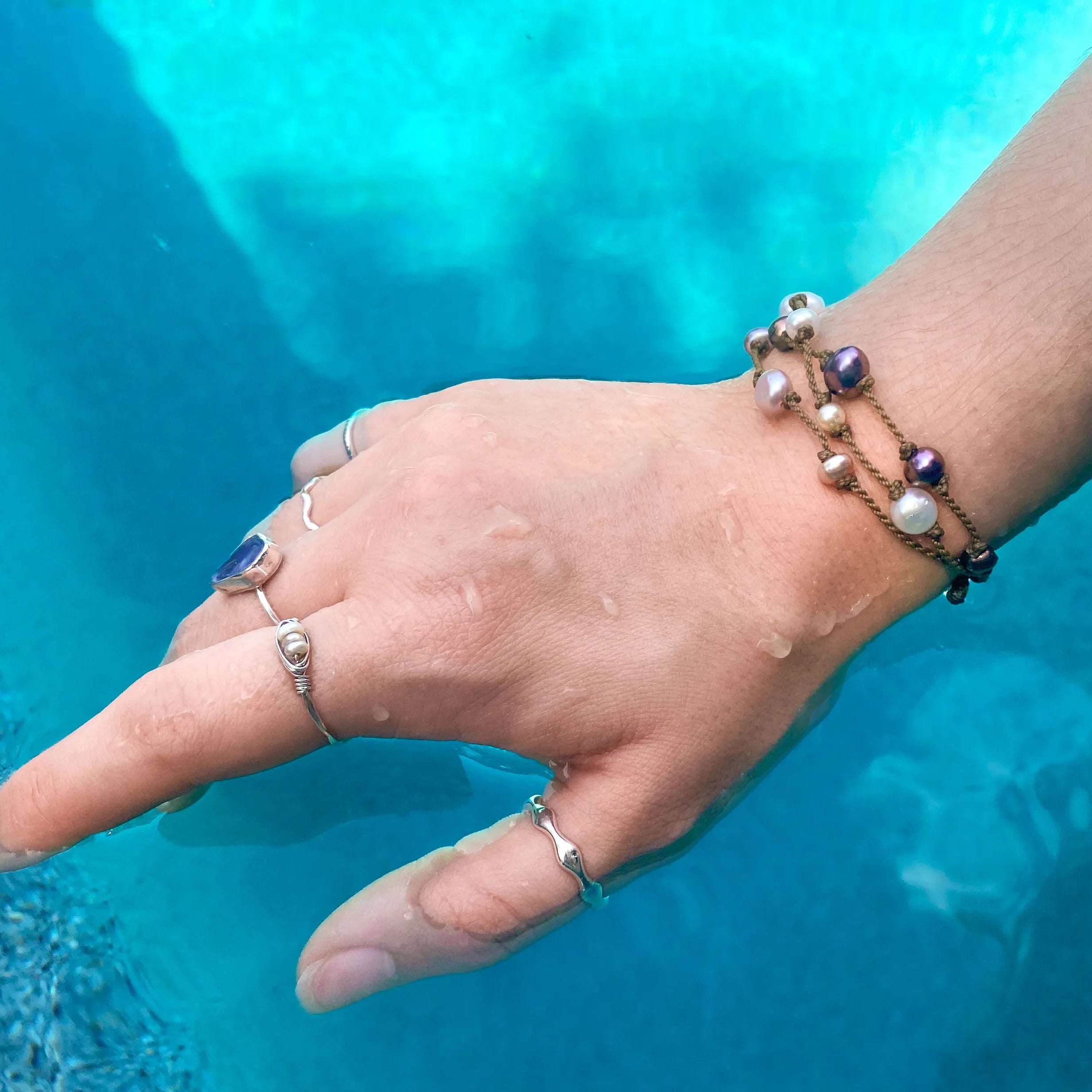 Tula Blue's Journey Bracelet in mixed pearl on model wrist in water