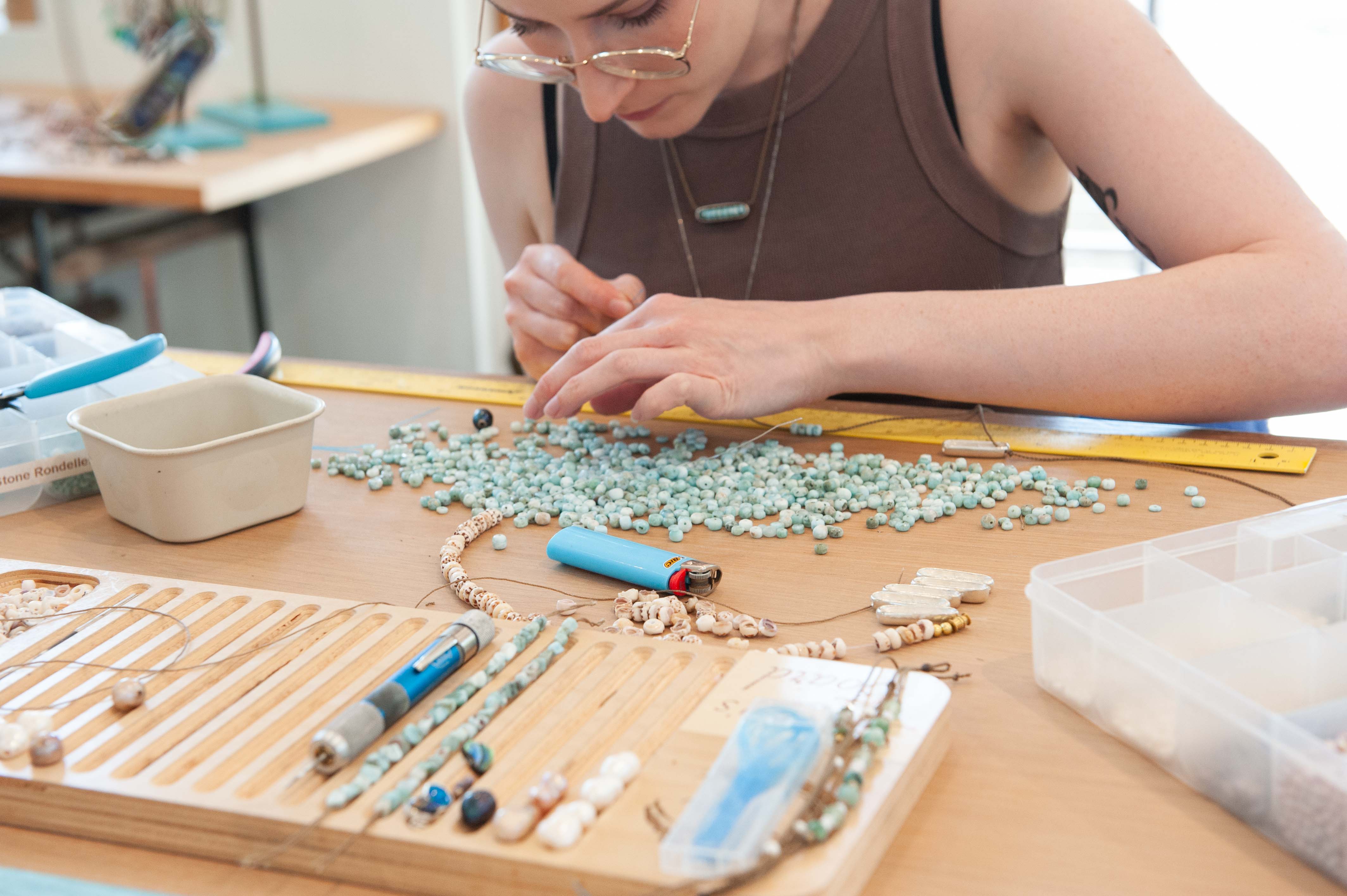 Tula Blue maker stringing Larimar onto nautical grade rope.