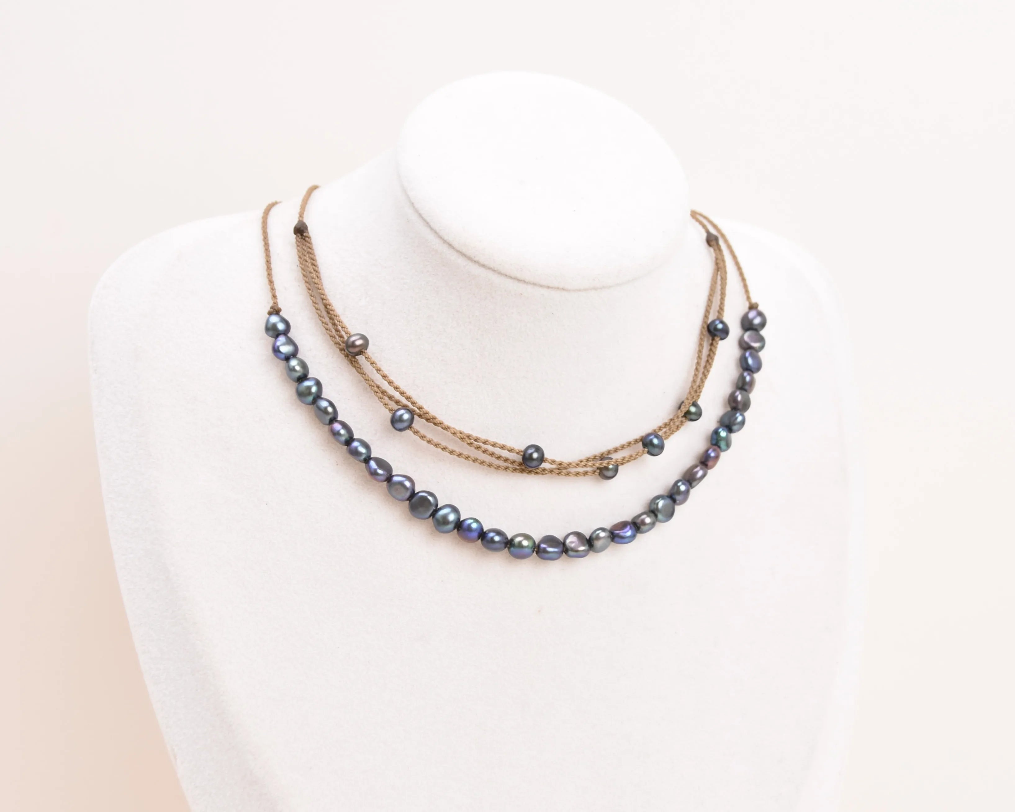 peacock pearl crown necklace and peacock pearl riptide necklace on bust