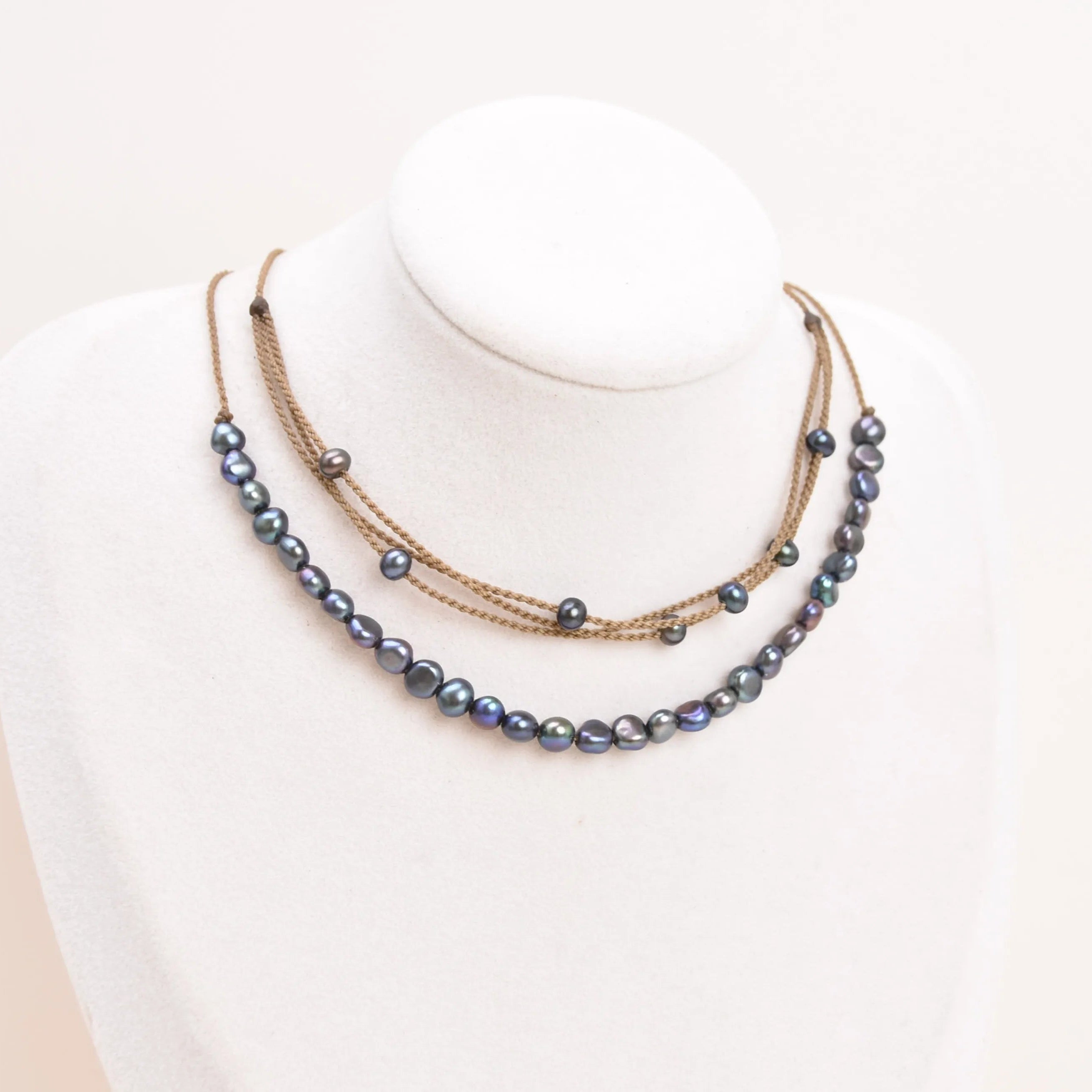 peacock pearl crown necklace and peacock pearl riptide necklace on bust