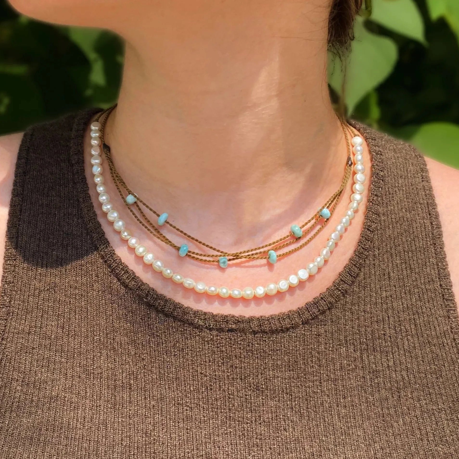 white pearl crown necklace and larimar riptide necklace on model