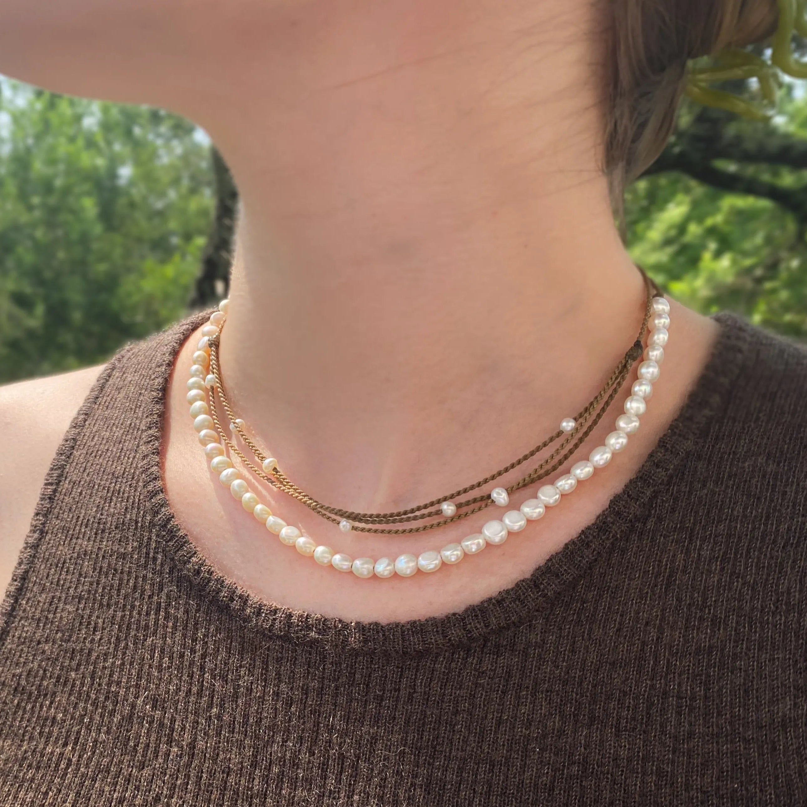 white pearl crown necklace and white pearl riptide necklace on model