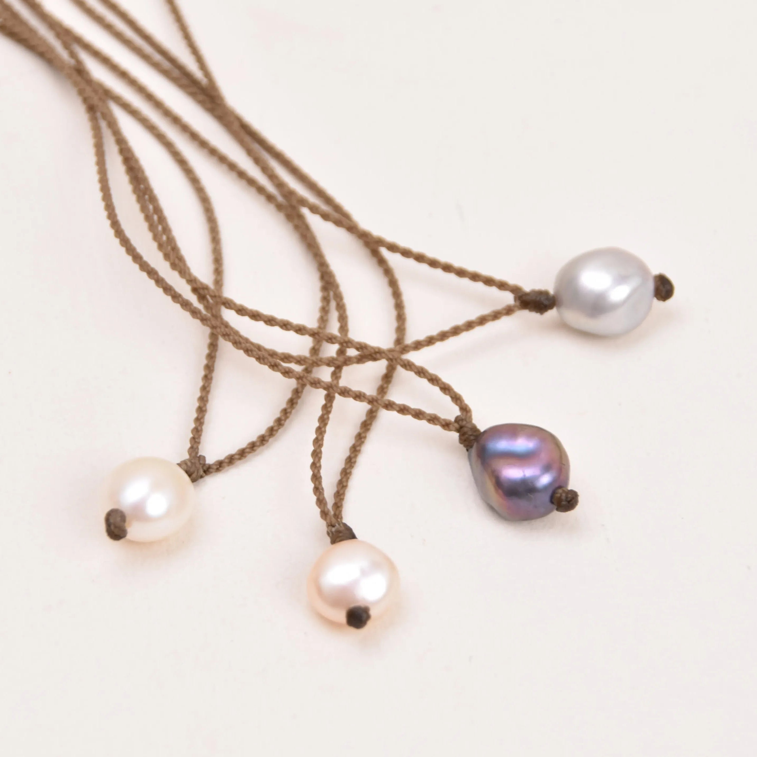 Pearl Drop Necklace in White, Peach, Peacock and Silver on a white background