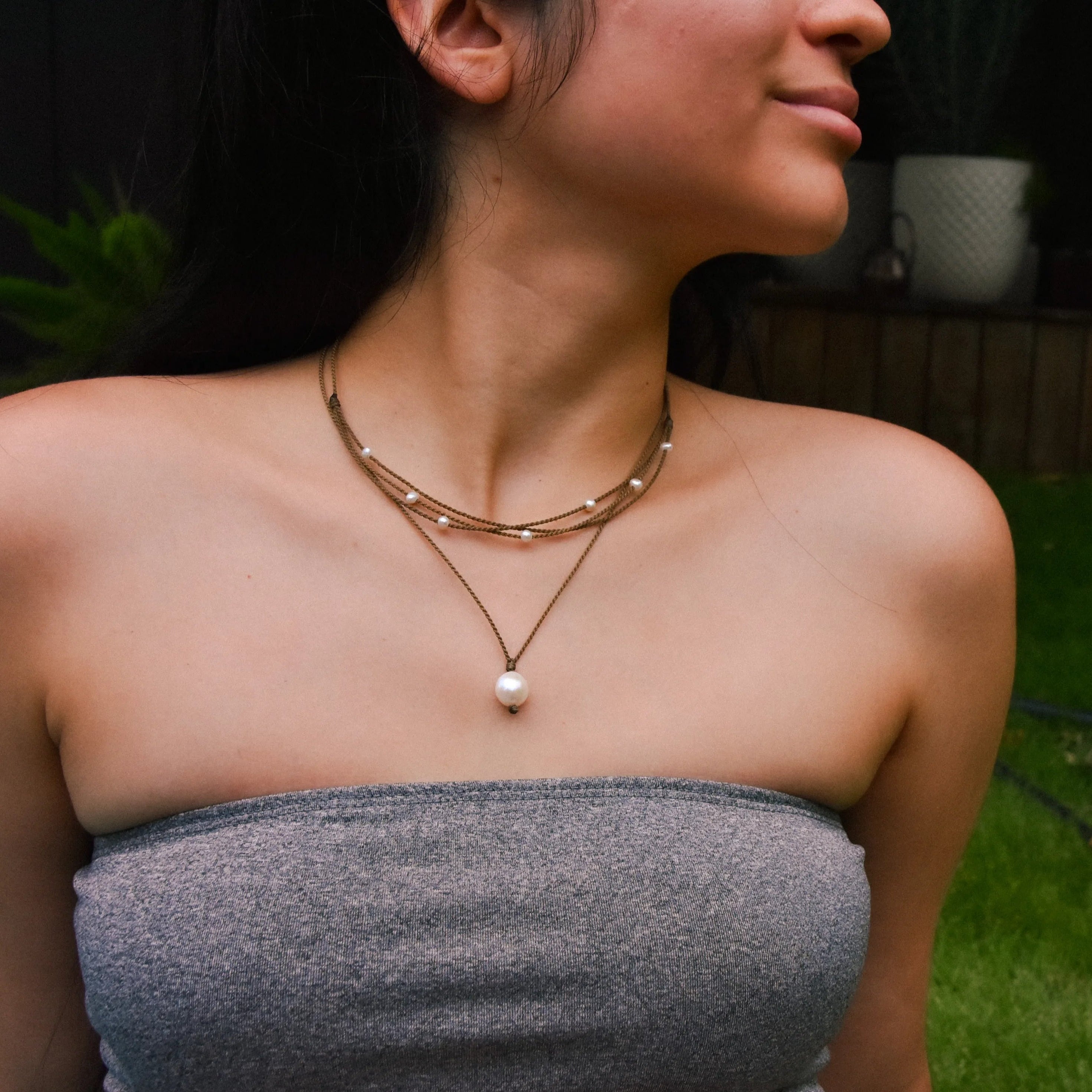 Pearl Drop Necklace in white on model paired with the white riptide necklace