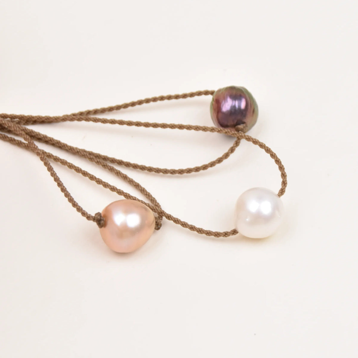 Three Classic Pearl Necklaces with peacock, blush, and white Edison freshwater pearls on hand-spun waterproof rope