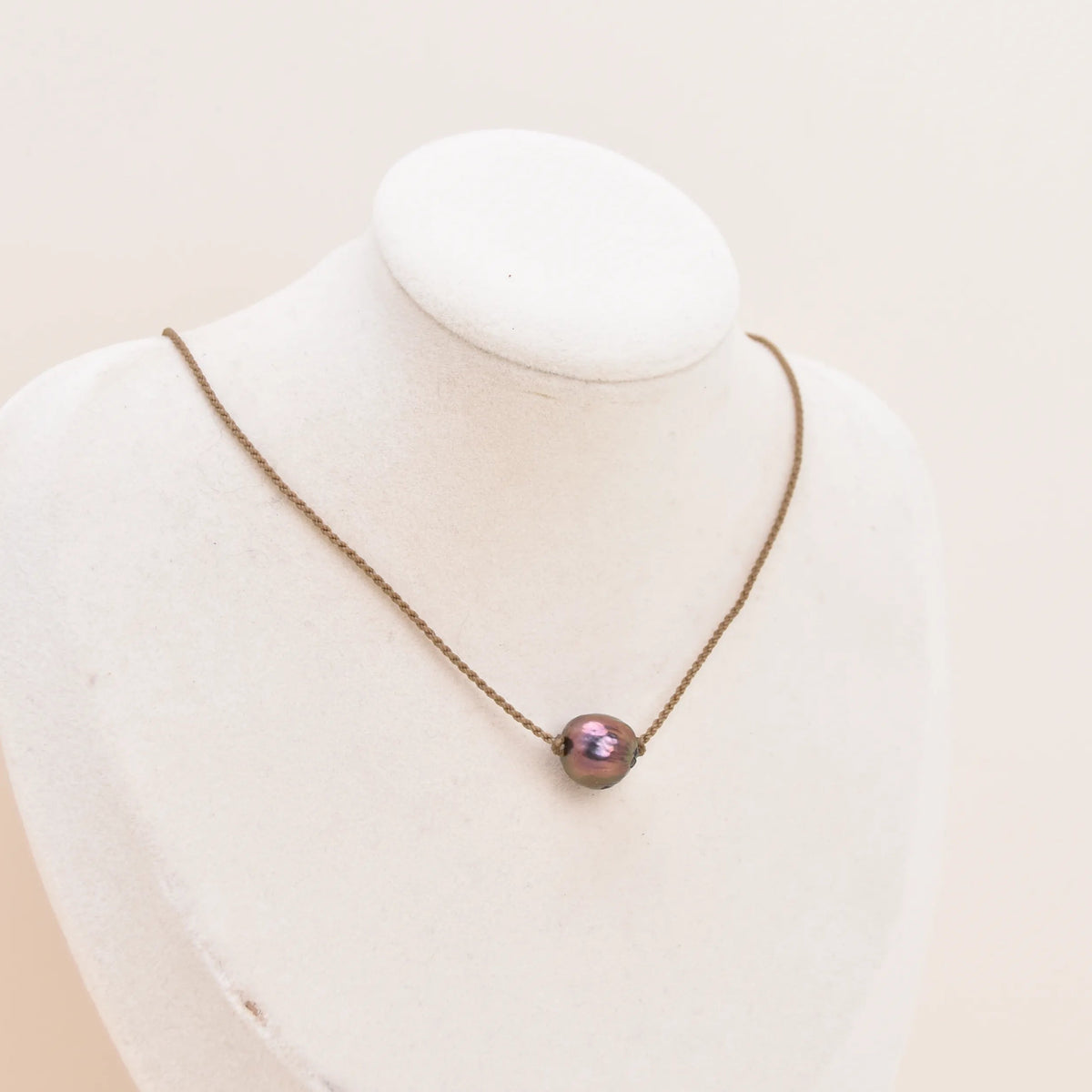 Classic Pearl Necklace with a peacock Edison freshwater pearl knotted on hand-spun rope, displayed on a bust