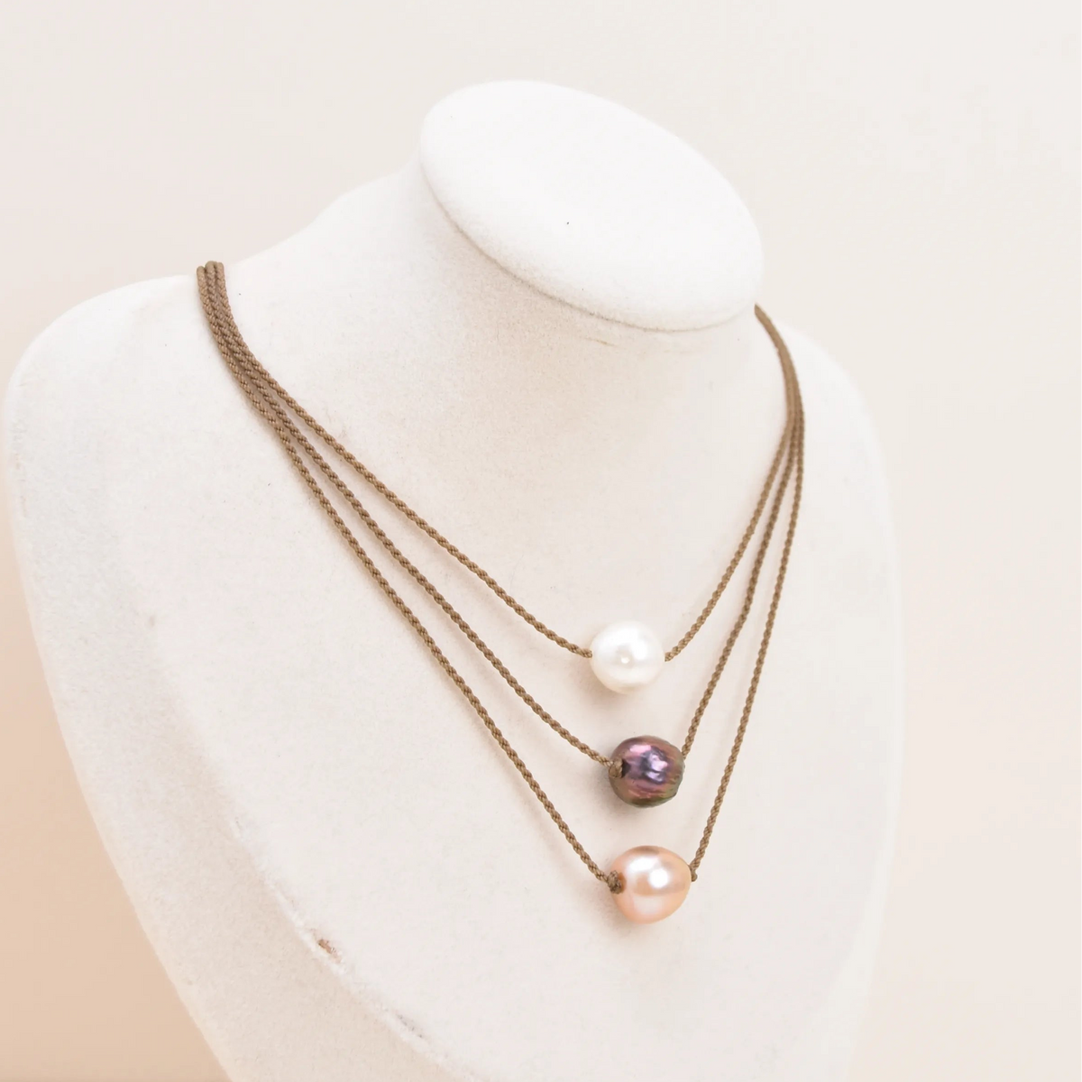 Three Classic Pearl Necklaces layered on a bust, with white, peacock, and blush Edison freshwater pearls on hand-spun rope