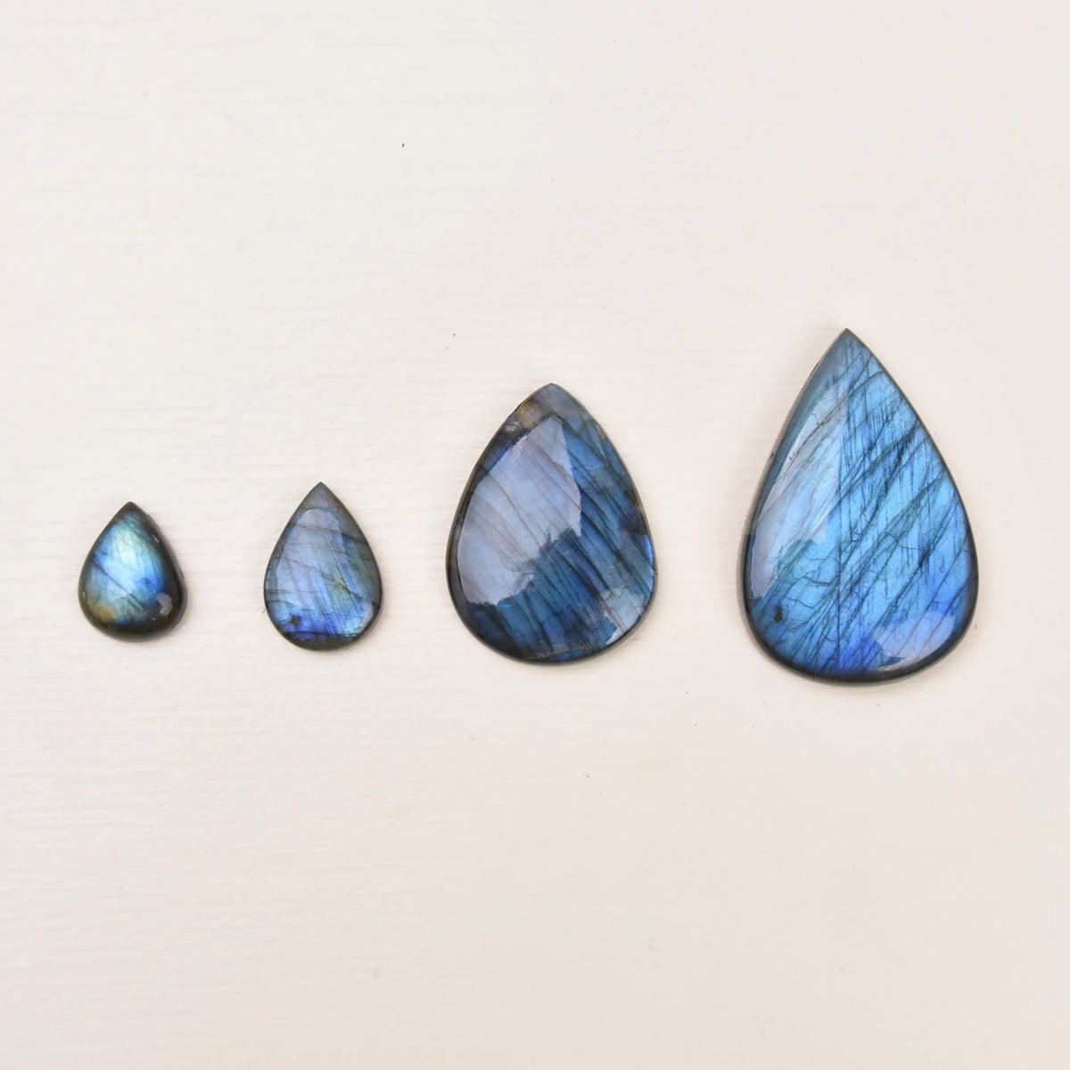 Labradorite Gemstone Pendant size comparison, four blue stones in a row from small to large