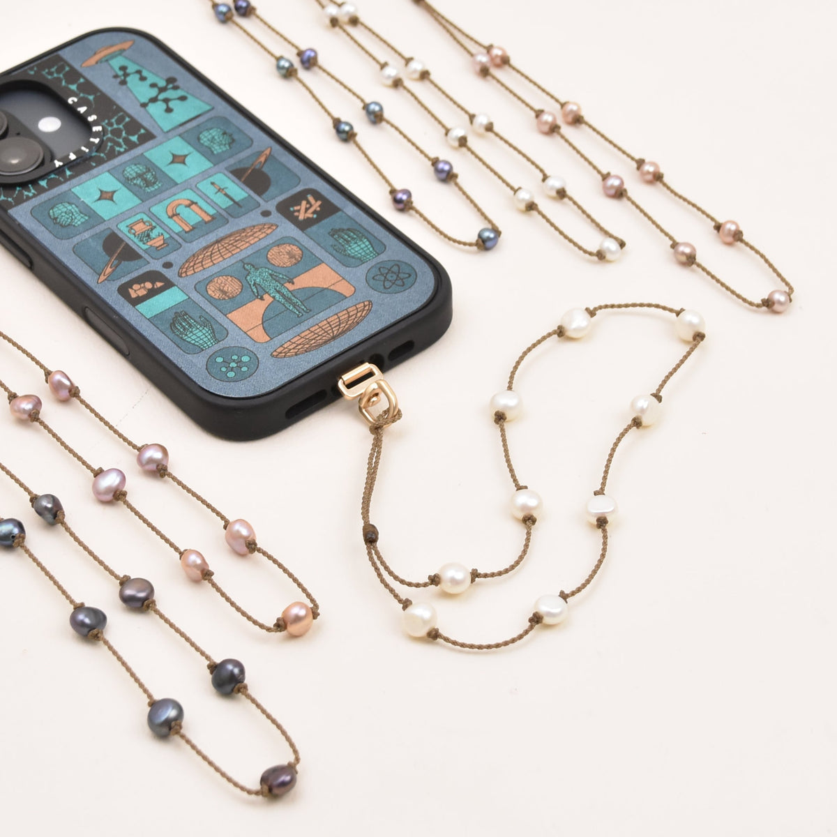 Medium baroque and oval freshwater pearl phone wristlet on hand-spun rope, looped through a phone case