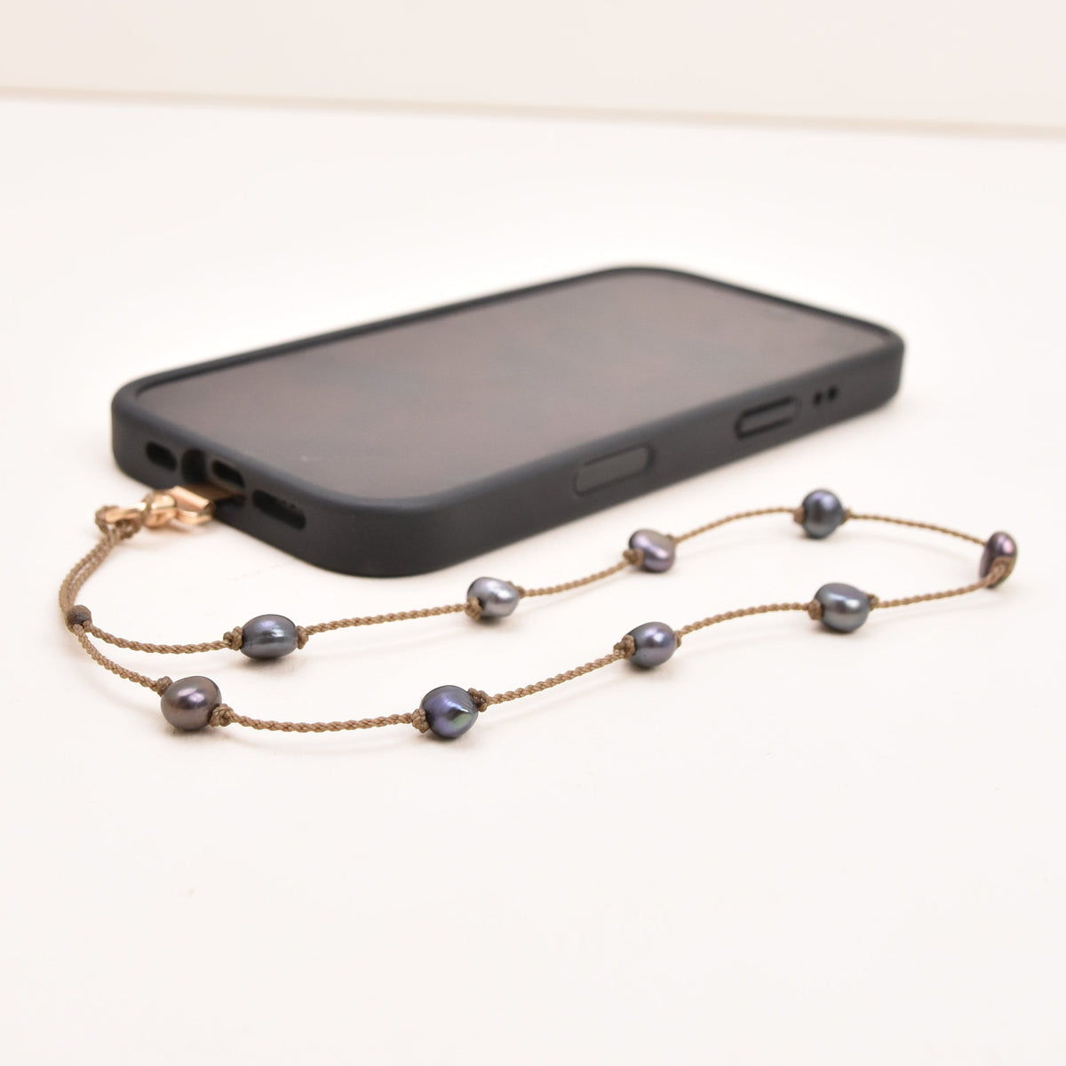 Peacock freshwater pearl phone strap on hand-spun rope with phone attached