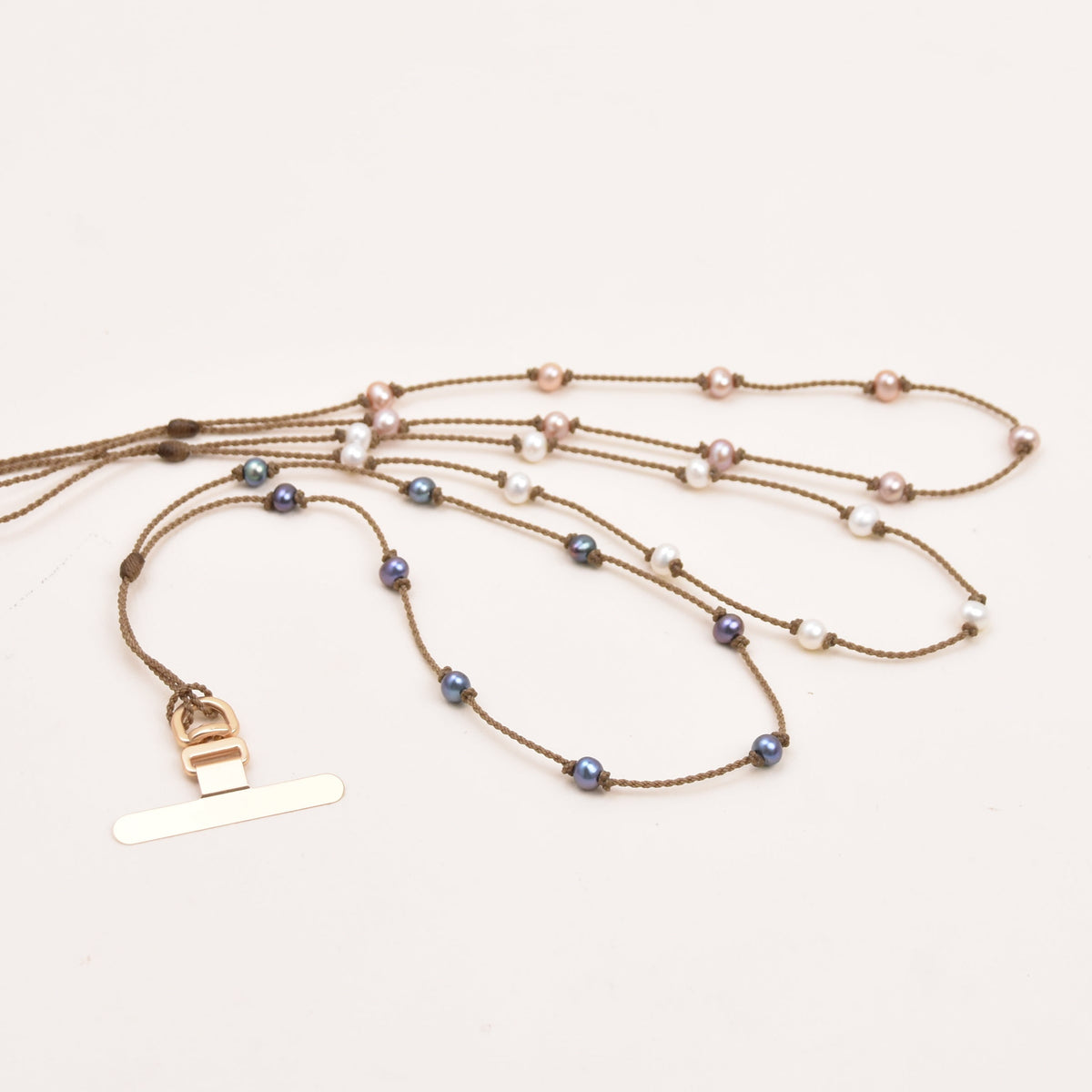 Pearl phone wristlet and optional metal case tab laid flat