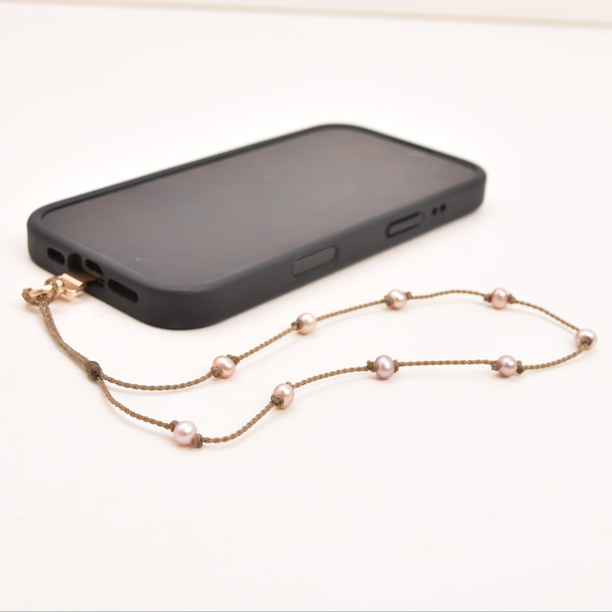 Blush freshwater pearl phone wristlet on hand-spun rope on a phone