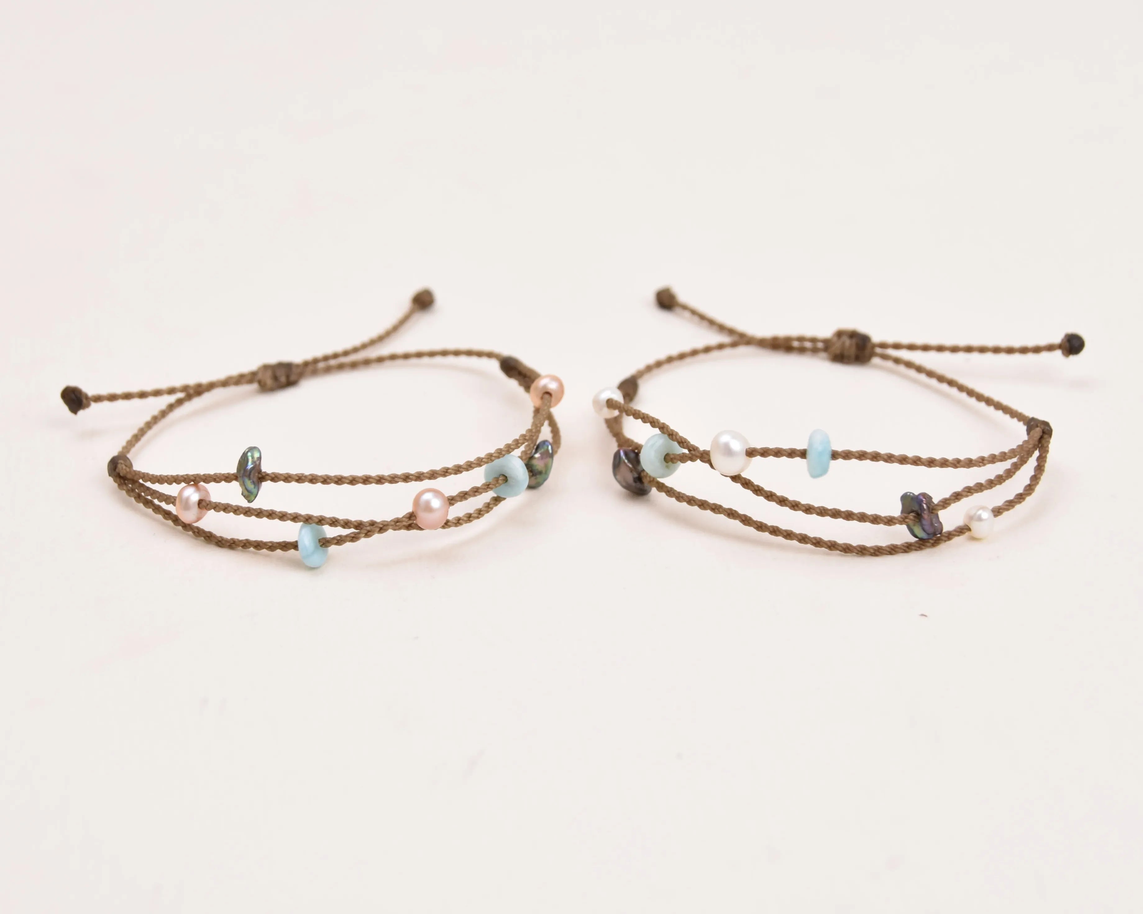 Seven Seas X PADI Riptide Bracelets with white and blush pearls on white background side by side