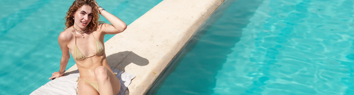 model in the sun wearing tula blue rope necklaces with pool in the background