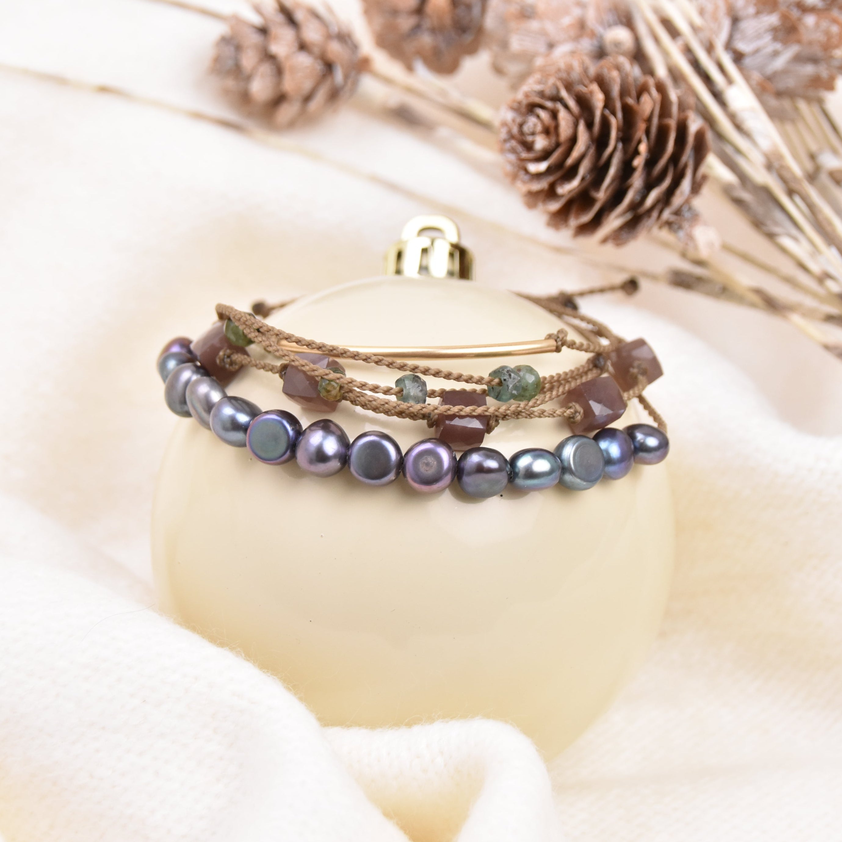 Multistrand pearl bracelet on a white surface with decorative elements
