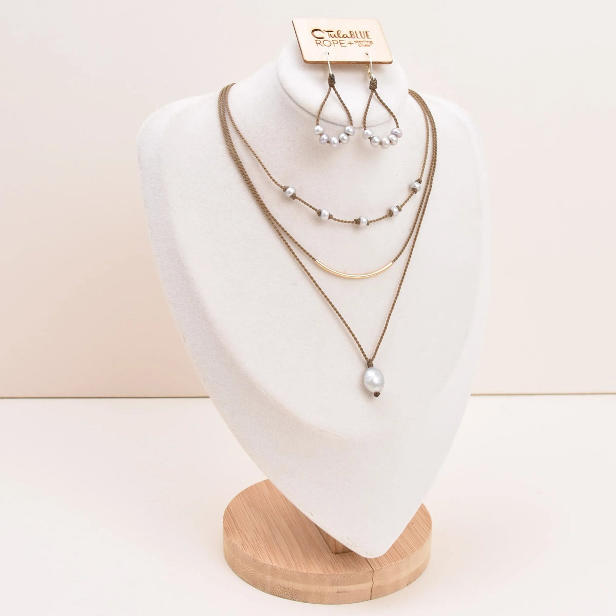 Dripping in Pearls necklace stack with earrings in silver on bust with white background