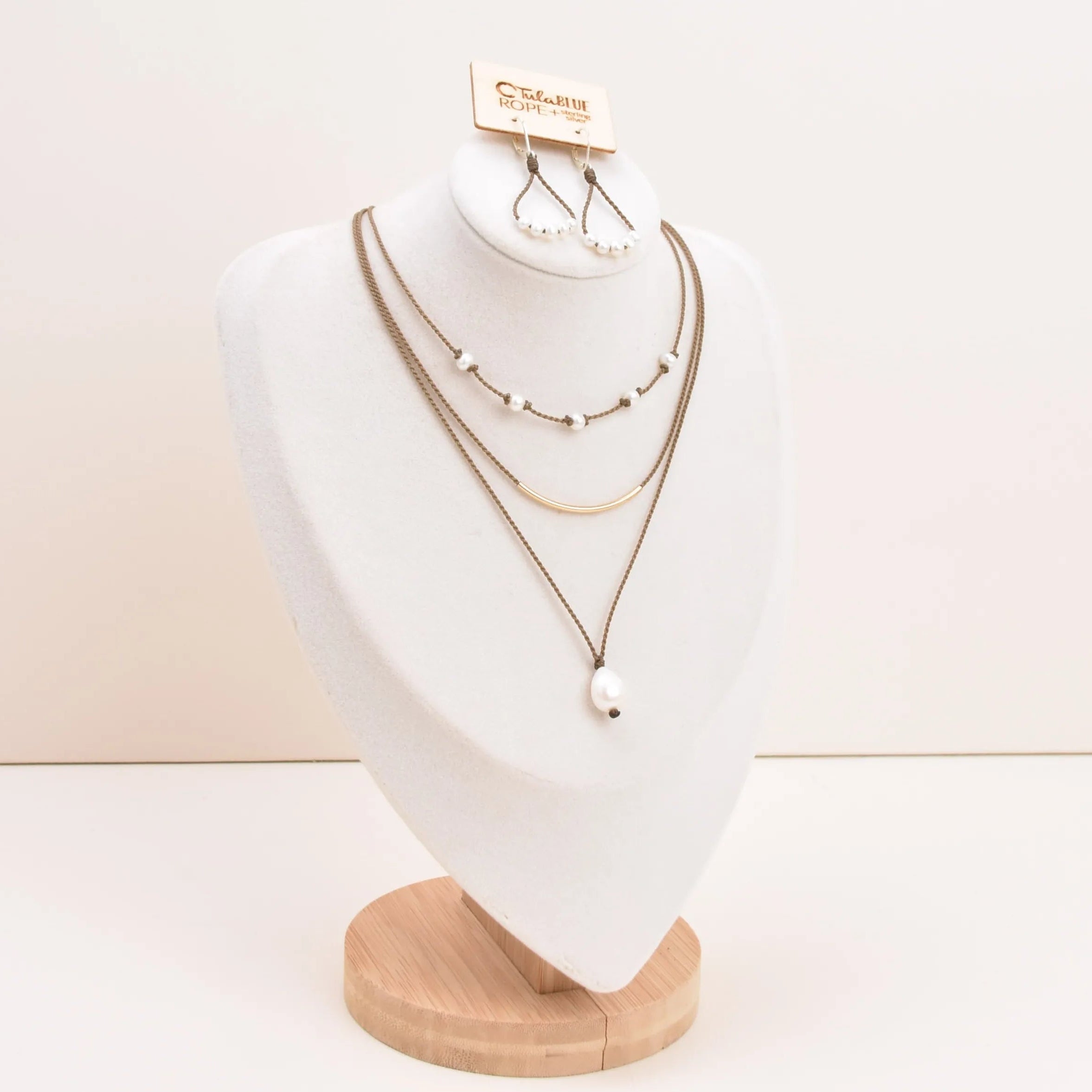 Dripping in Pearls necklace stack in white on bust with earrings and white background