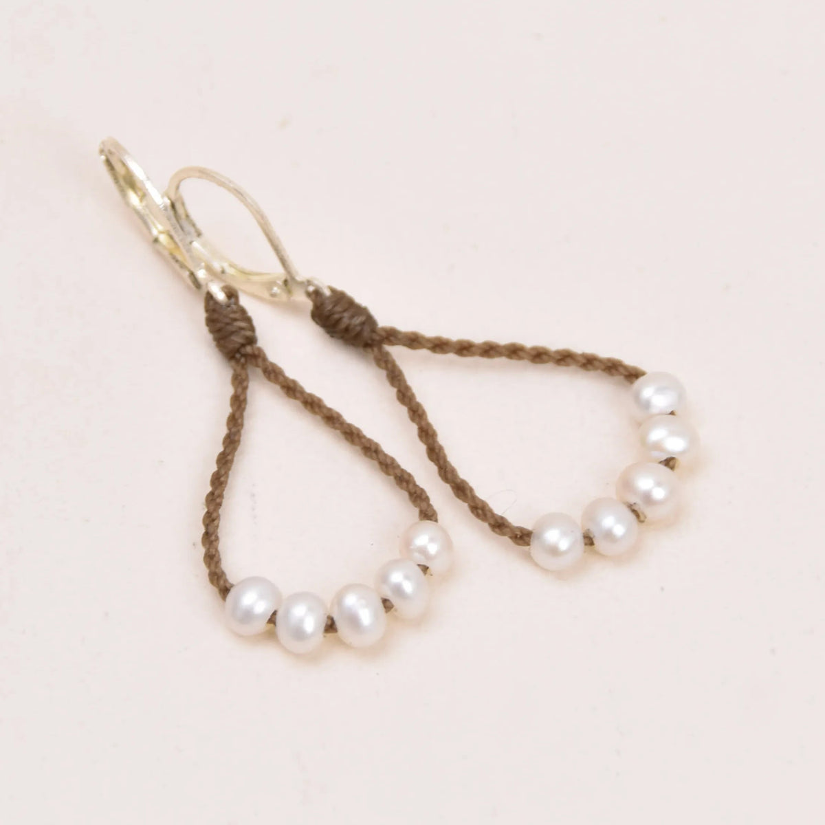 dainty pearl earrings in white layout on white background