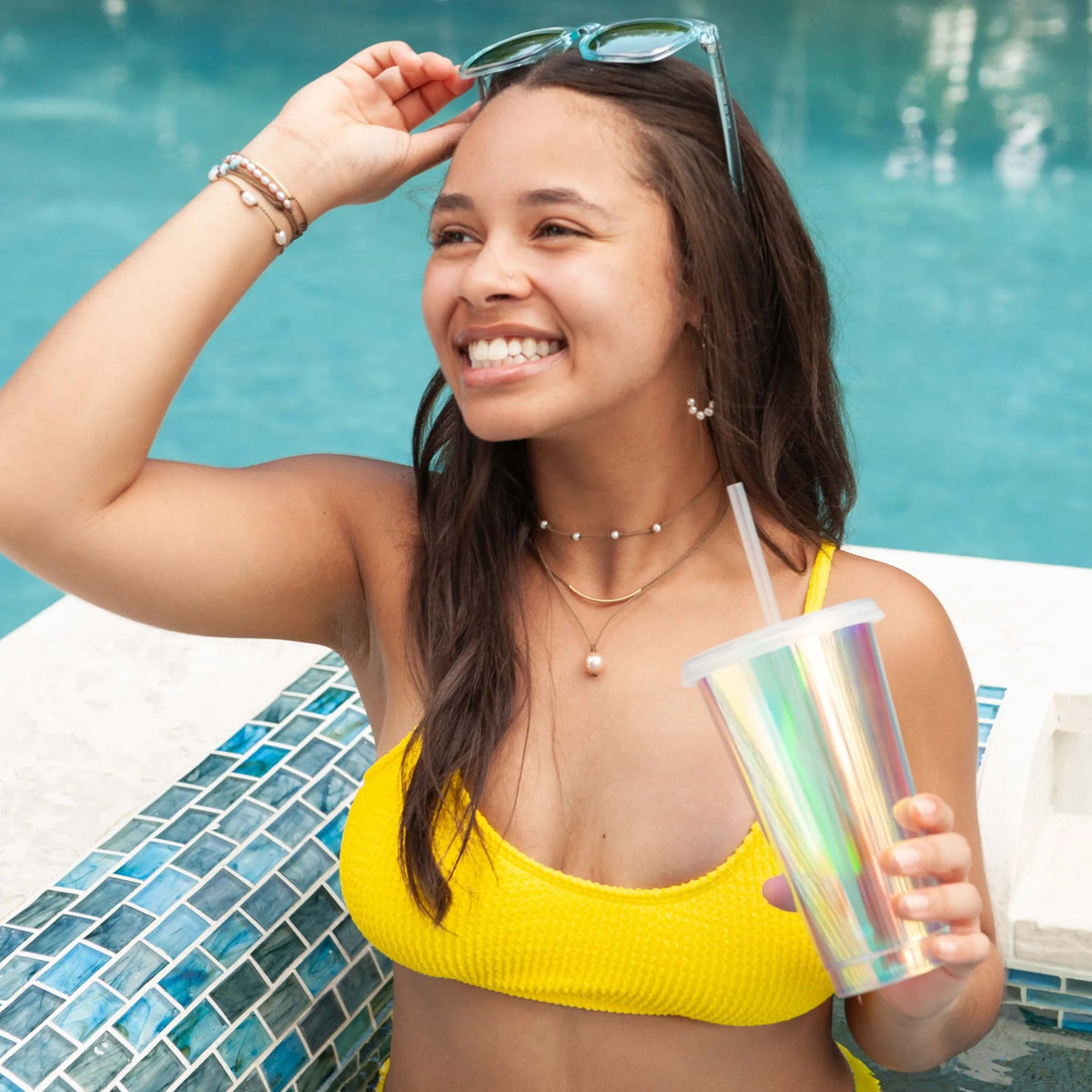 Dripping in Pearls necklace stack in white with earrings on model in swimming pool