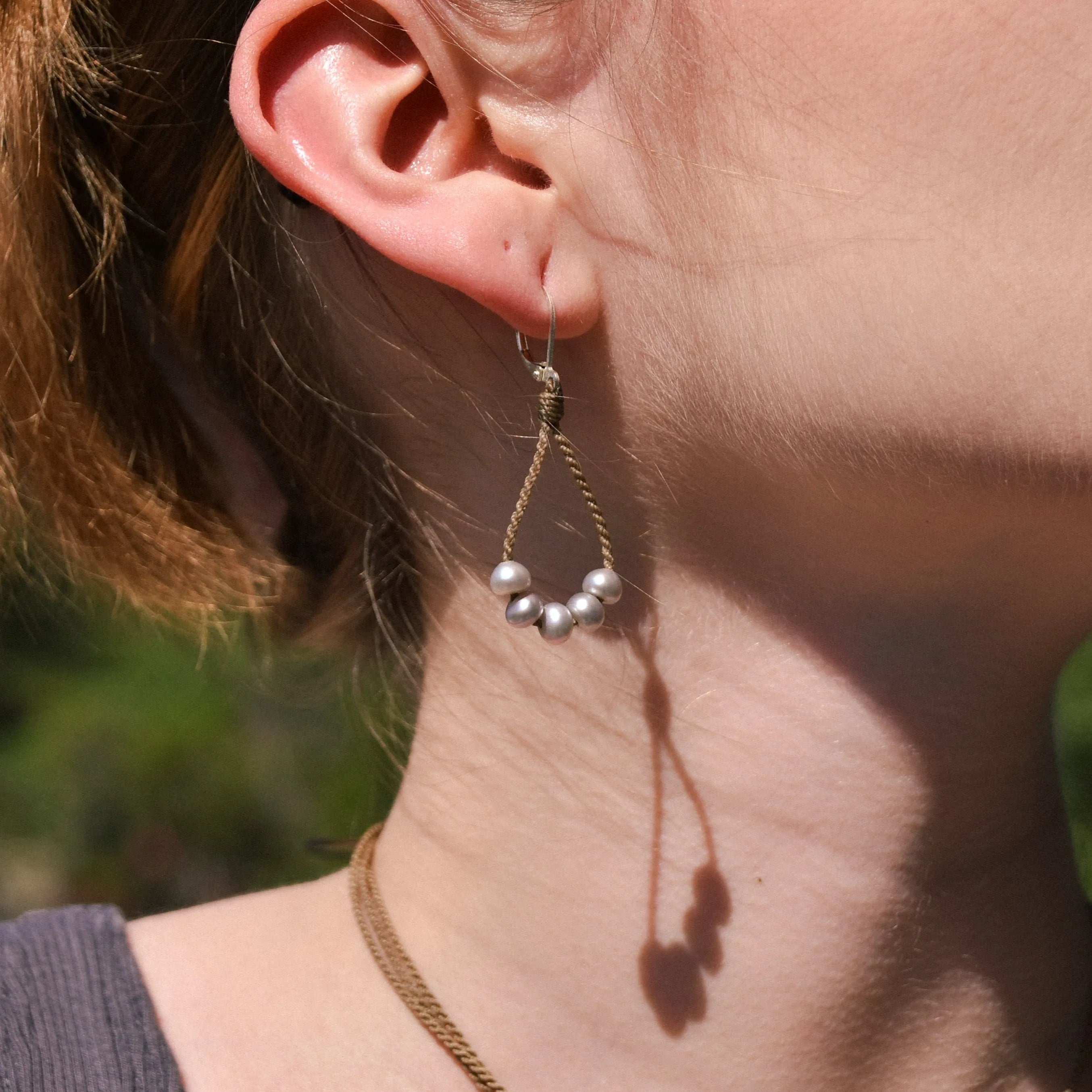 dainty pearl earrings in silver on model closeup