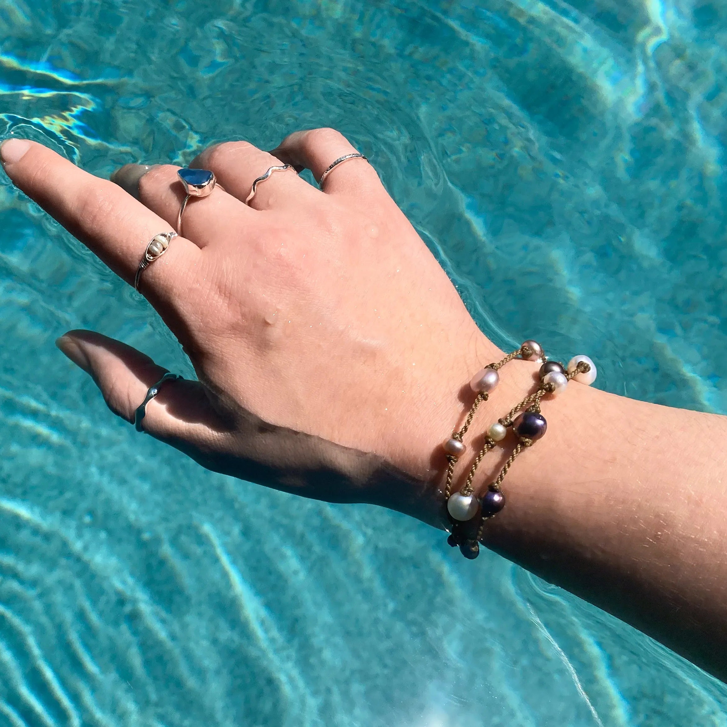 Tula Blue's Journey Bracelet in mixed pearl on model wrist in water