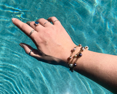 Tula Blue's Journey Bracelet in mixed pearl on model wrist in water