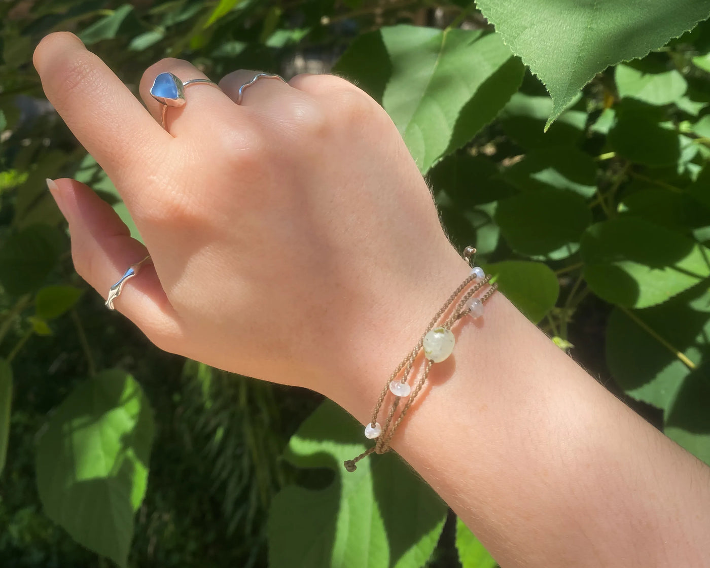 Mental Health Matters Riptide Bracelet on model's wrist in front of green leaves