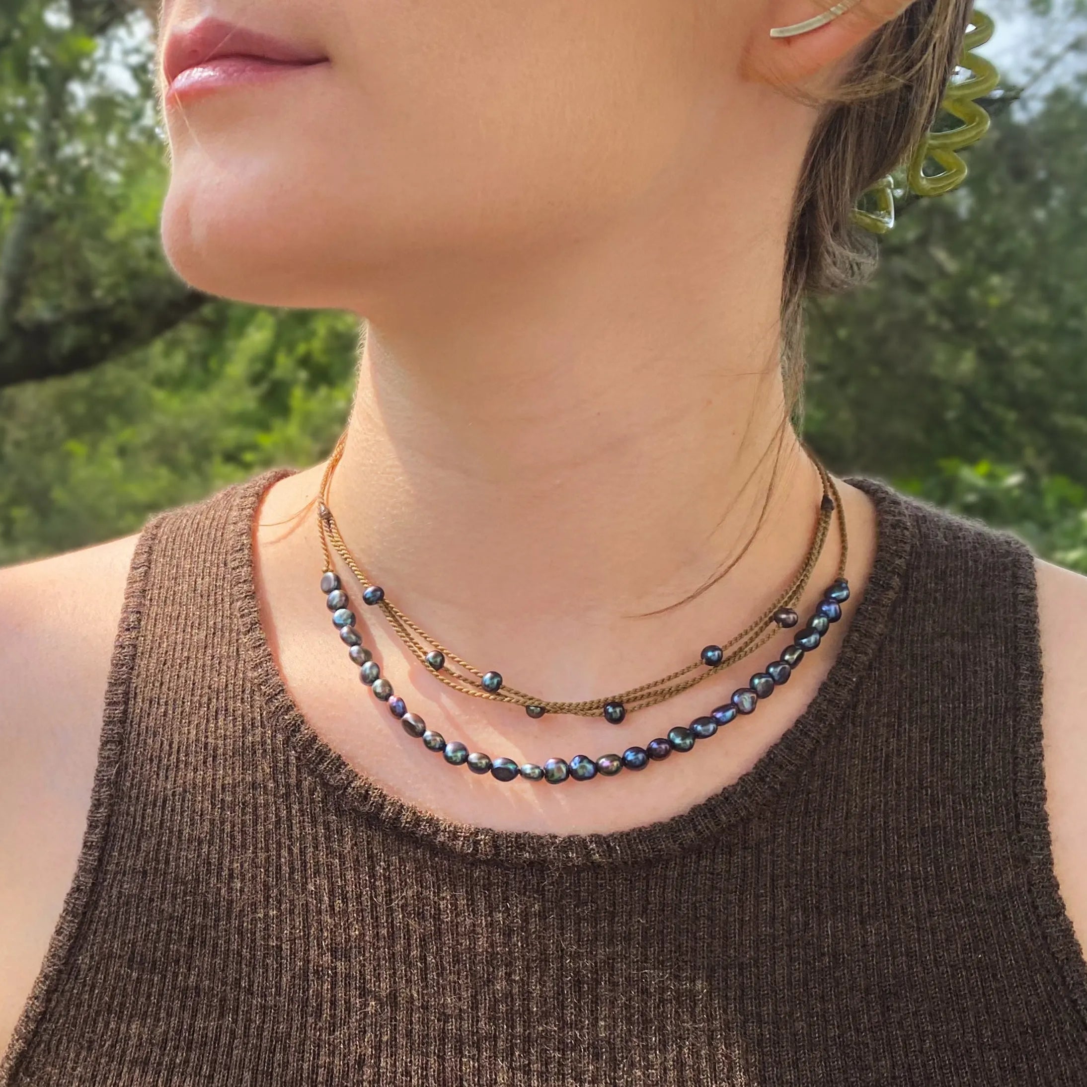 peacock pearl crown necklace and peacock pearl riptide necklace on model