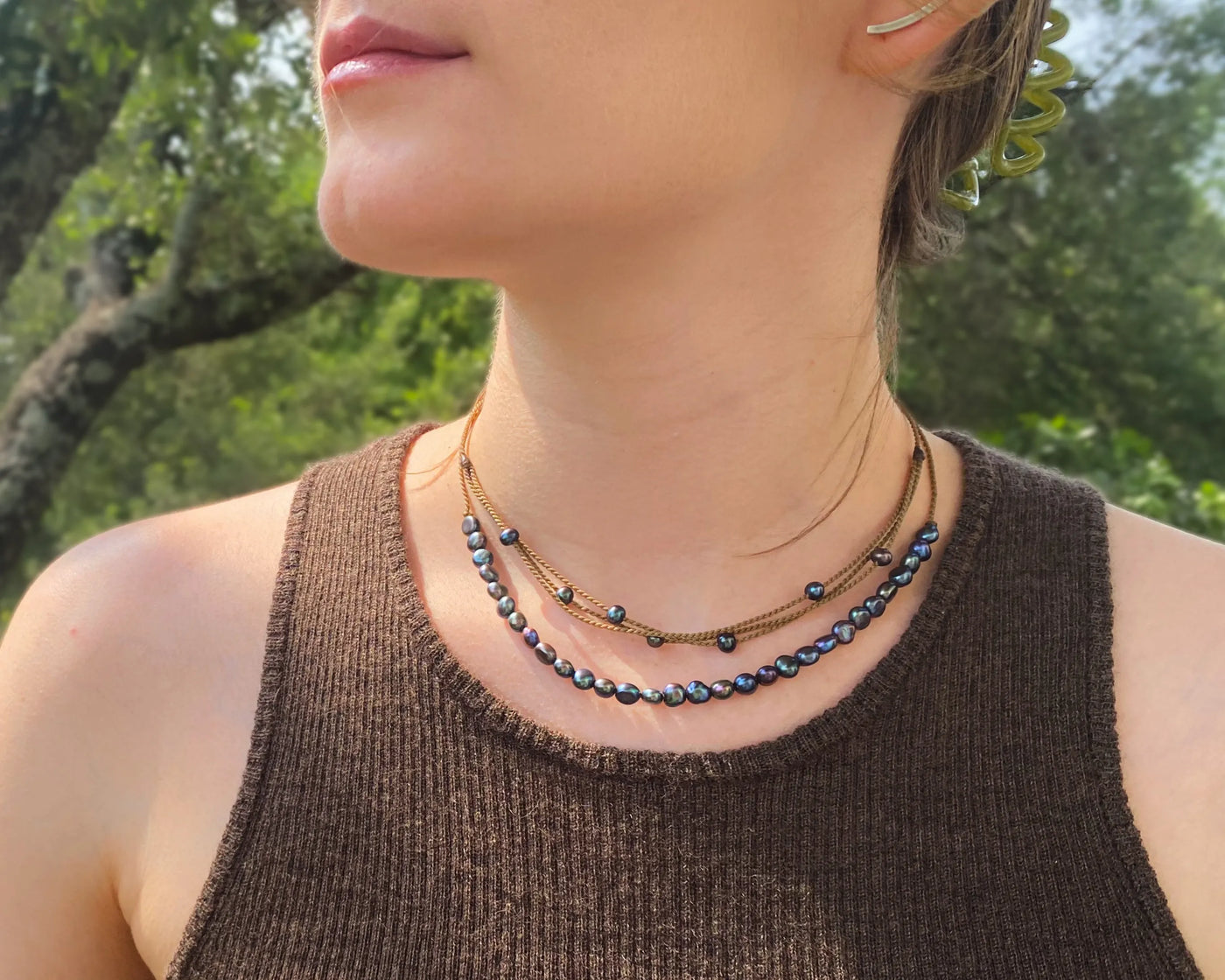 peacock pearl crown necklace and peacock pearl riptide necklace on model