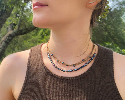 peacock pearl crown necklace and peacock pearl riptide necklace on model