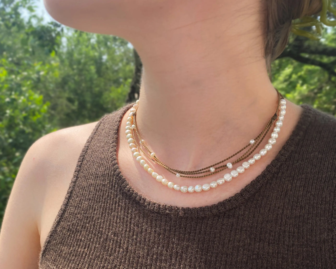 white pearl crown necklace and white pearl riptide necklace on model