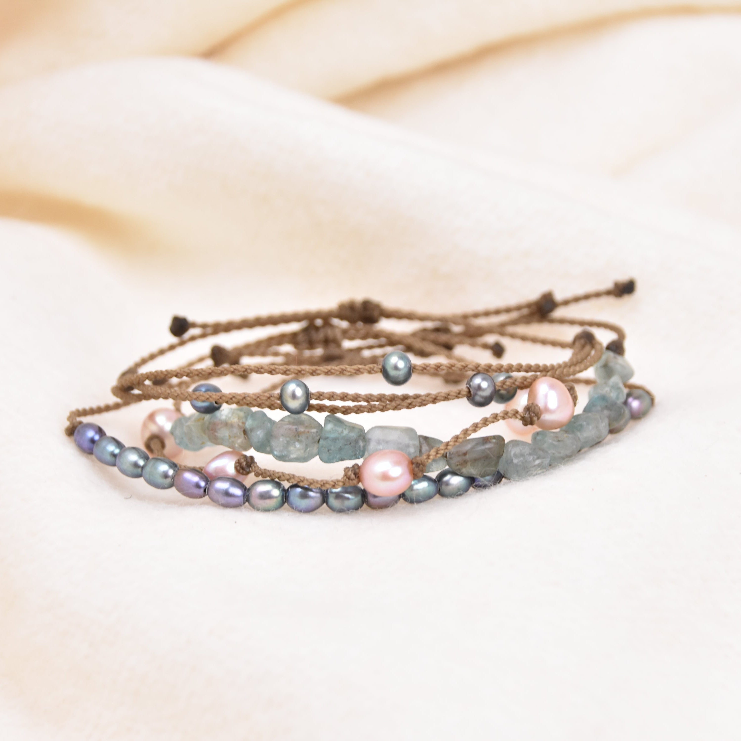 Set of beaded bracelets on a soft beige fabric background