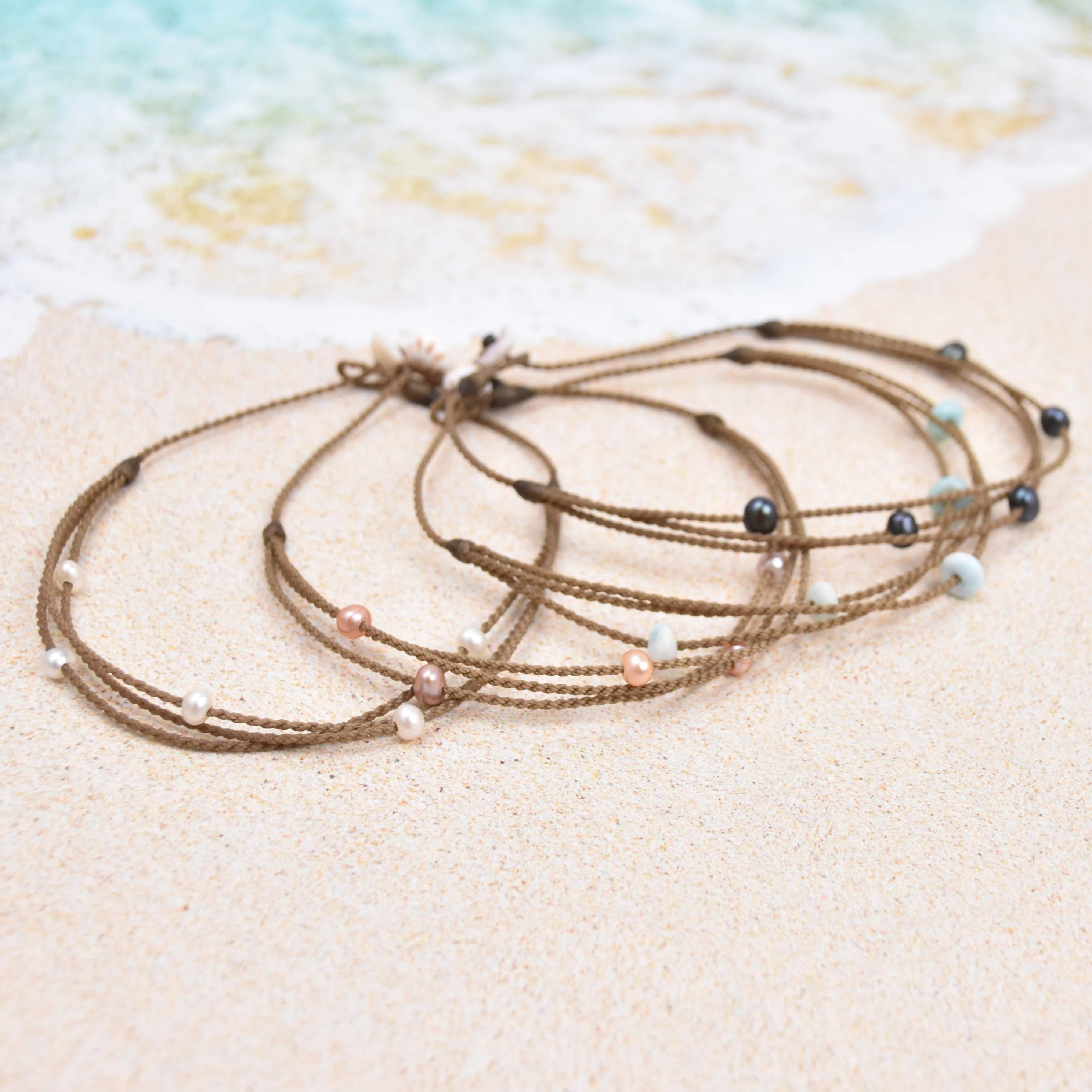 Tula Blue's waterproof Riptide anklet options in white pearls, blush pearls, larimar stones and peacock pearls. 