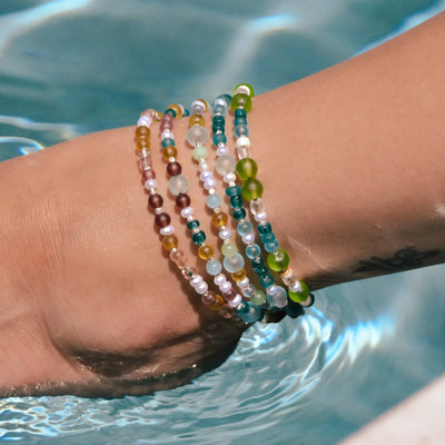 All sea glass anklets on one model's ankle in the pool water