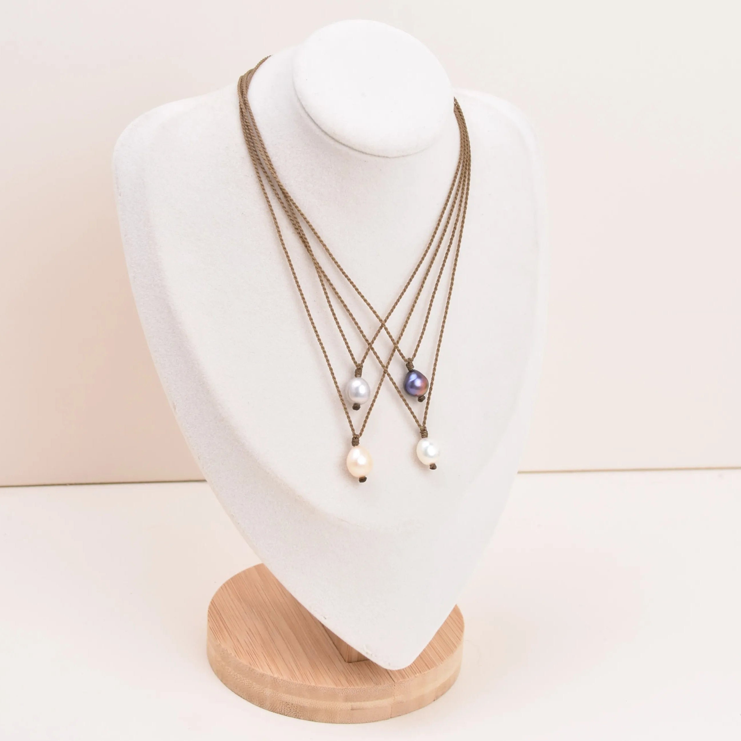 Pearl Drop Necklace in White, Blush, Peacock and Silver all on a white bust