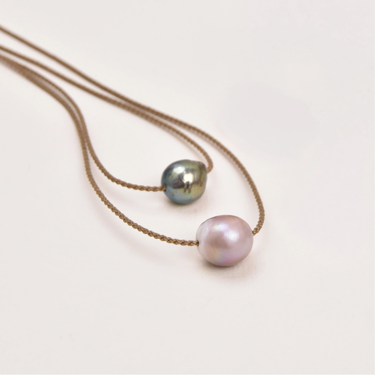 Two Classic Pearl Necklaces without knots, one with a peacock Edison freshwater pearl and one with a blush pearl, on hand-spun rope