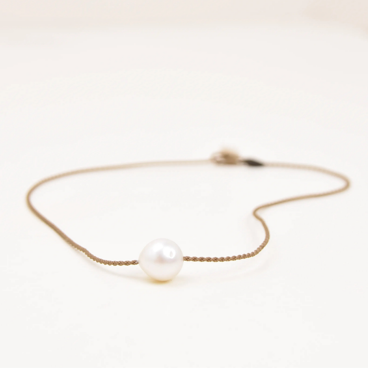 Classic Pearl Necklace laid flat, one white Edison freshwater pearl on hand-spun waterproof rope