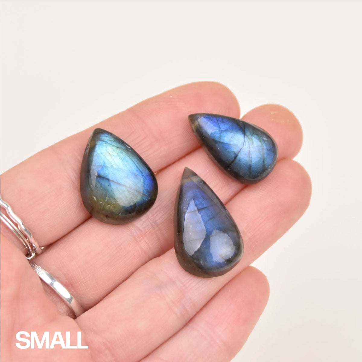 Labradorite Gemstone Pendant in size small, three blue flash stones held in hand for scale
