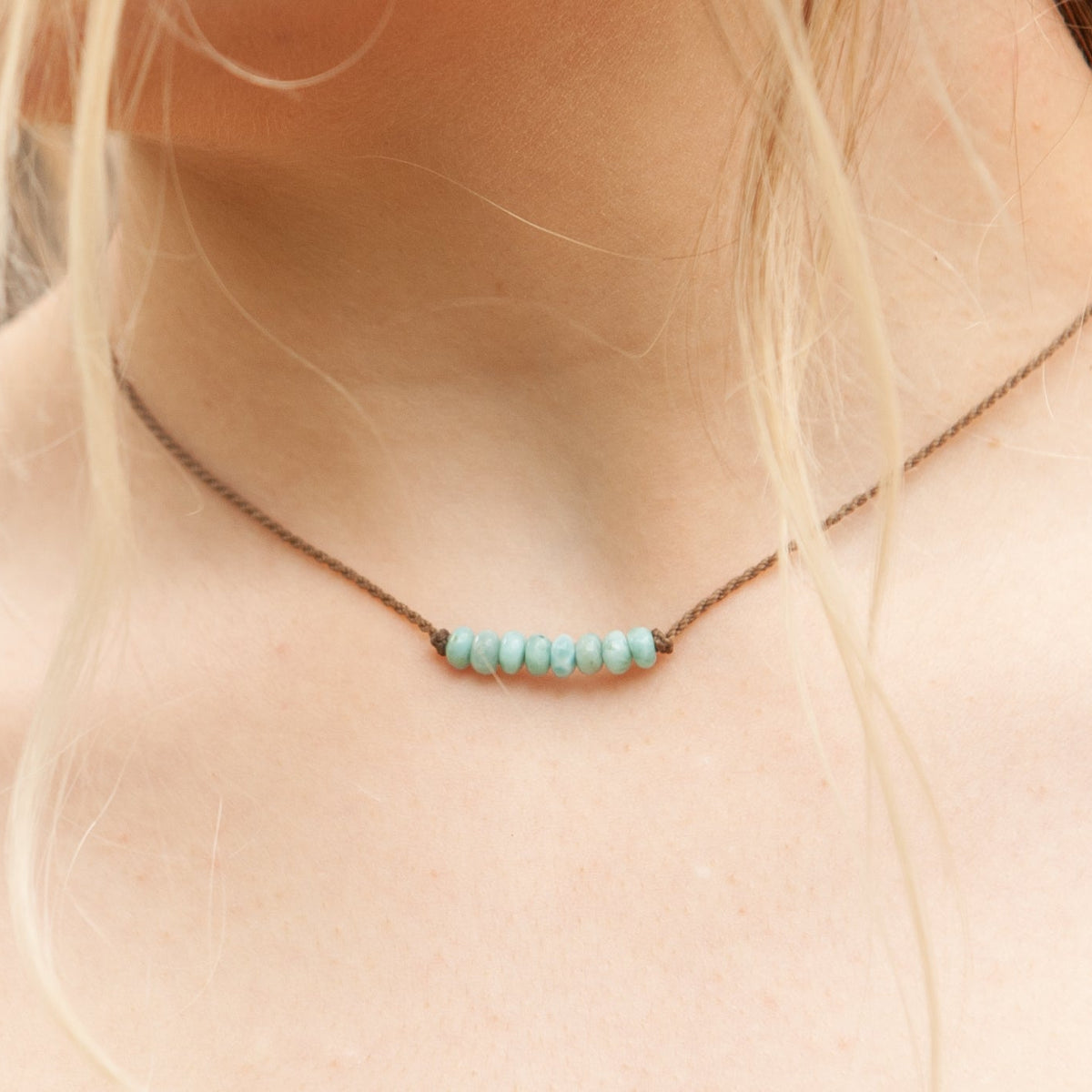 Close-up of the Live In Stone Necklace in larimar worn at the collarbone