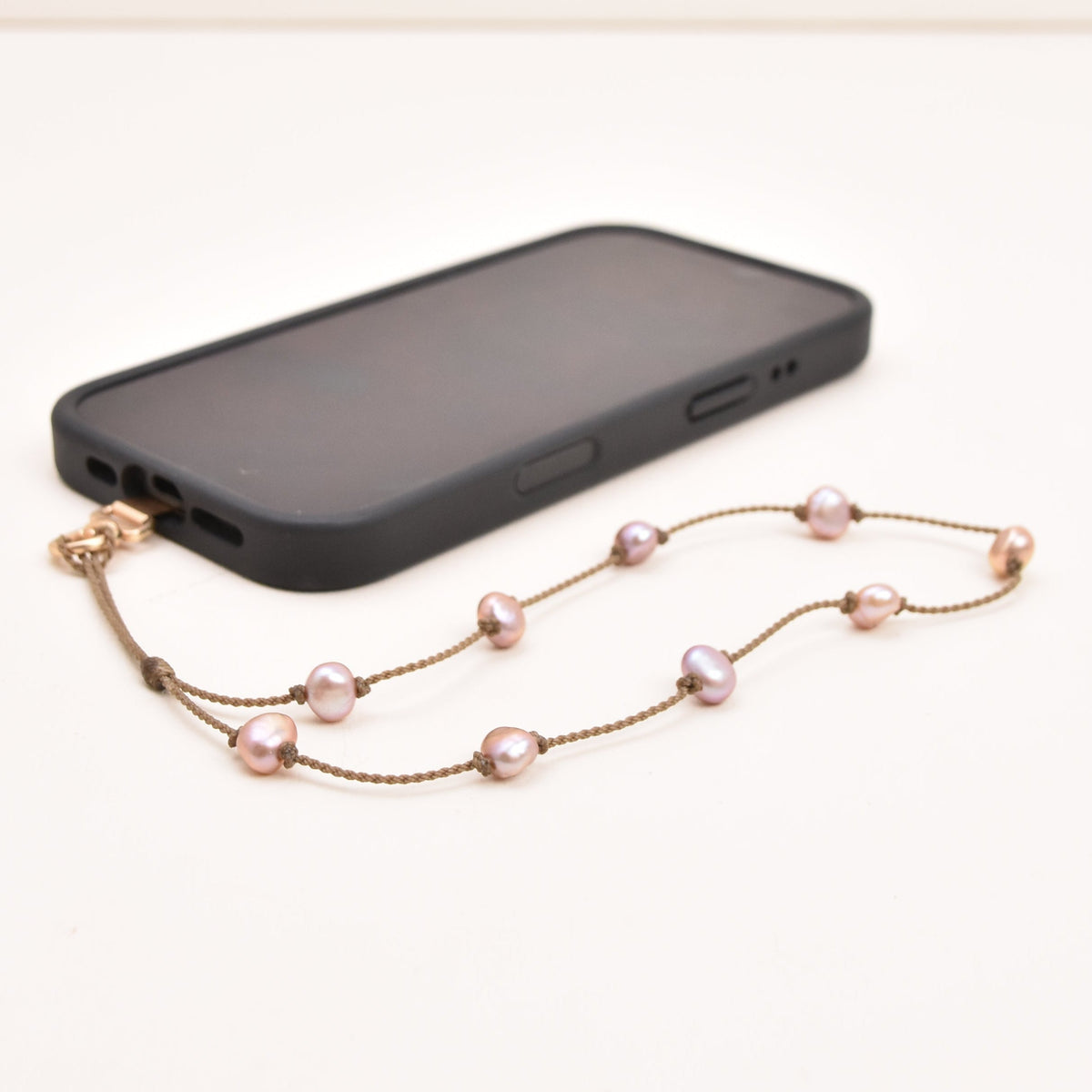 Blush freshwater pearl phone wristlet on hand-spun rope on a wrist