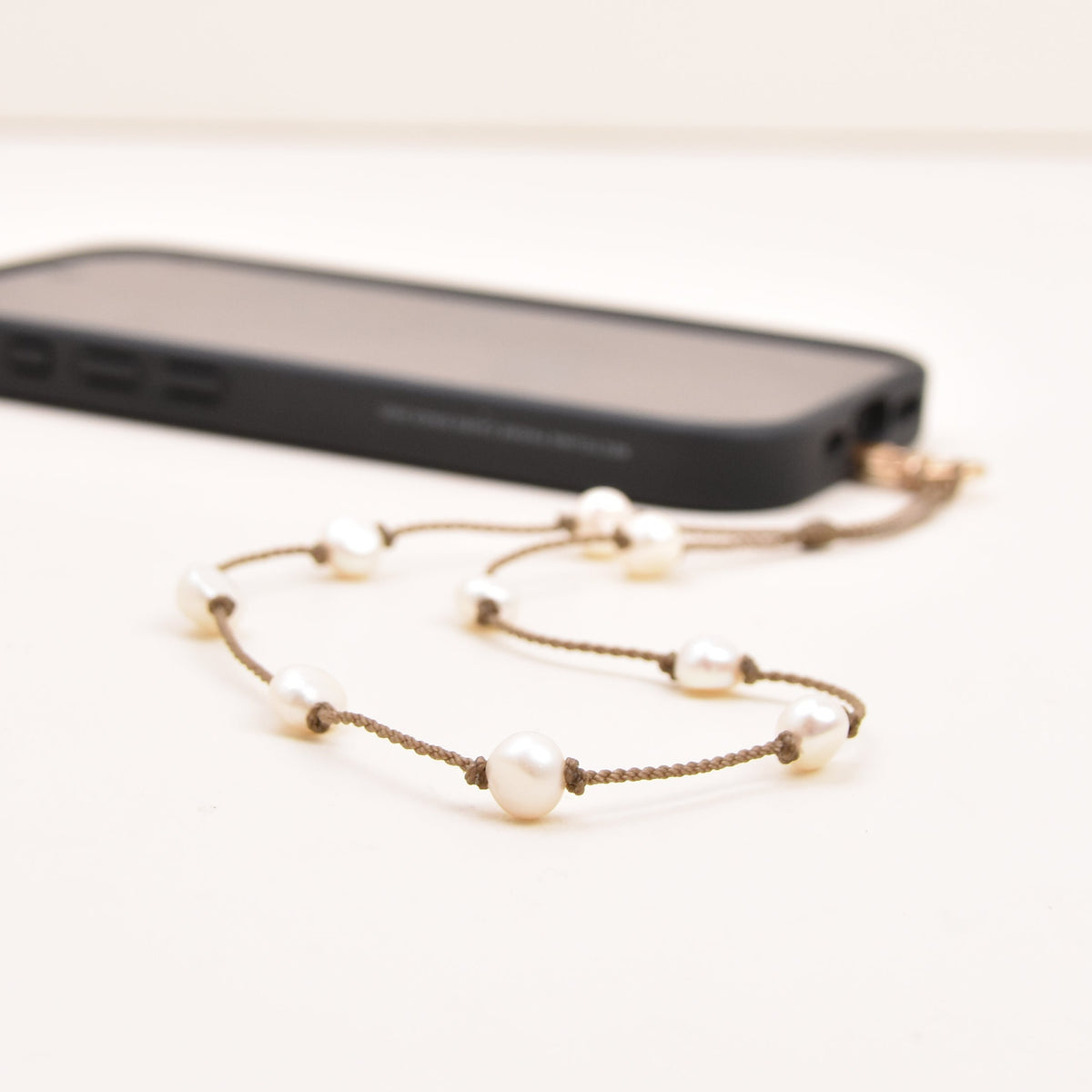 Close-up of freshwater pearls on hand-spun rope on a pearl phone wristlet