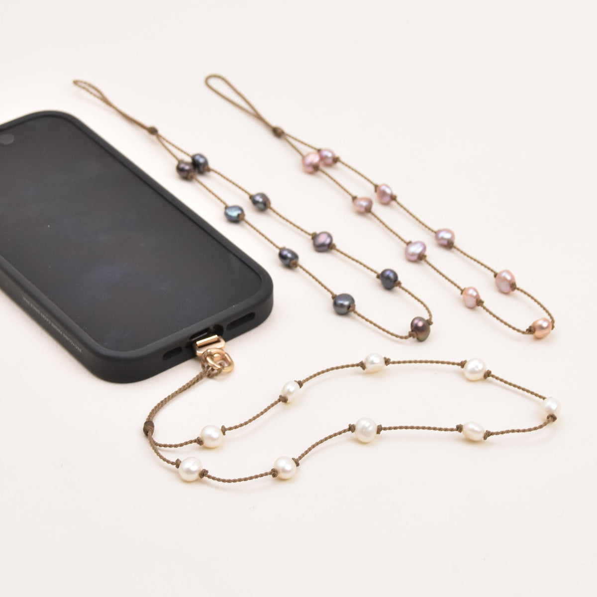 Close-up of medium baroque freshwater pearls on hand-spun rope on a pearl phone wristlet.