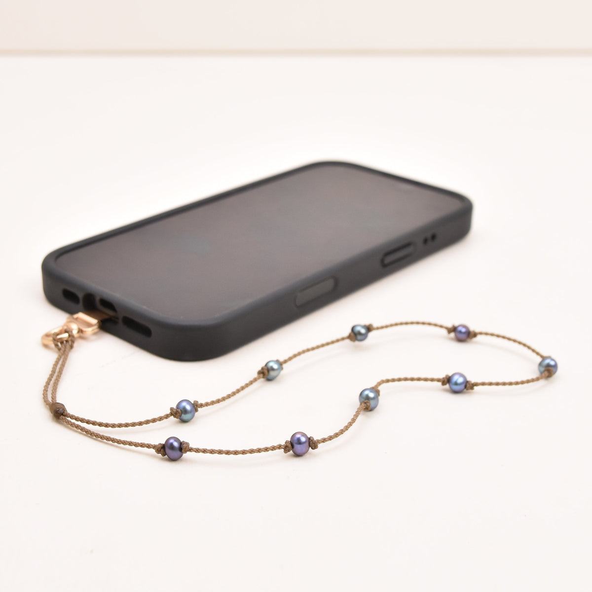 Peacock freshwater pearl phone strap on hand-spun rope with phone attached